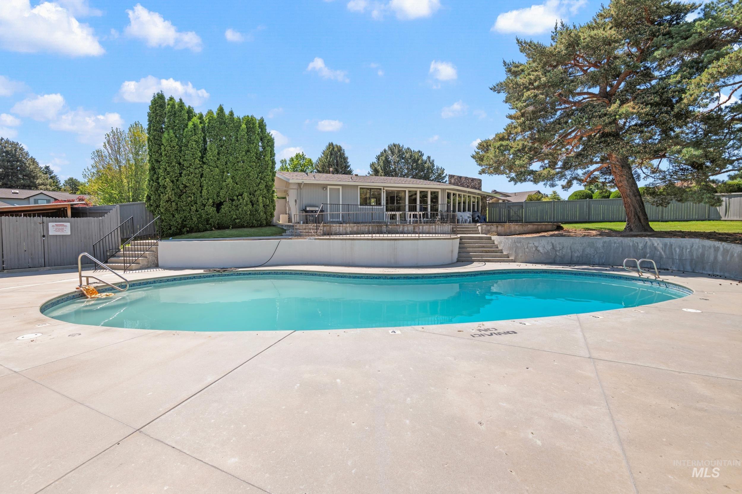 View of pool with a patio, stairway, and a wooden deck