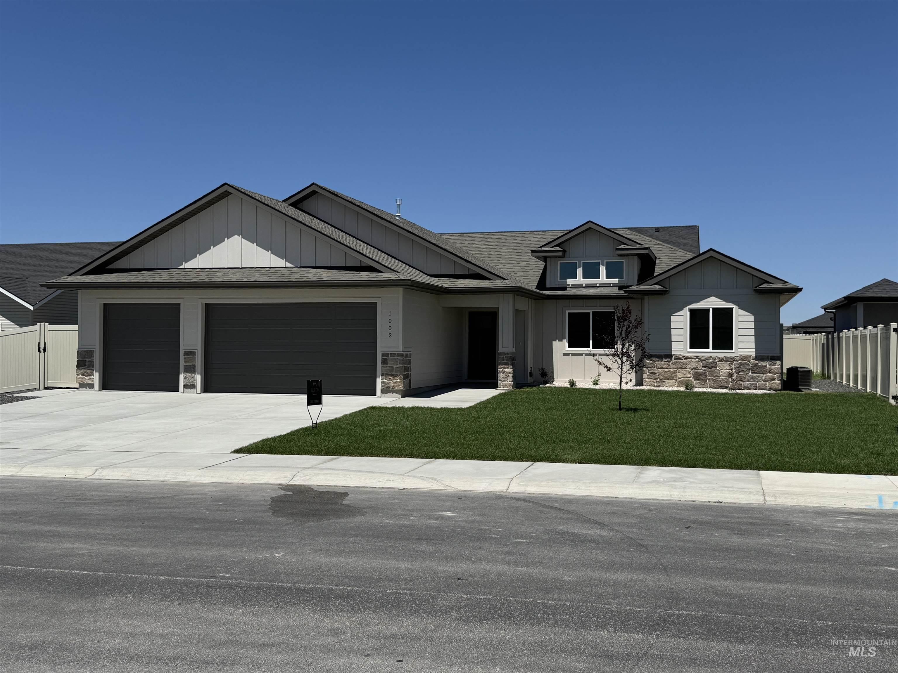 Craftsman house featuring board and batten siding, stone siding, an attached garage, concrete driveway, and a shingled roof