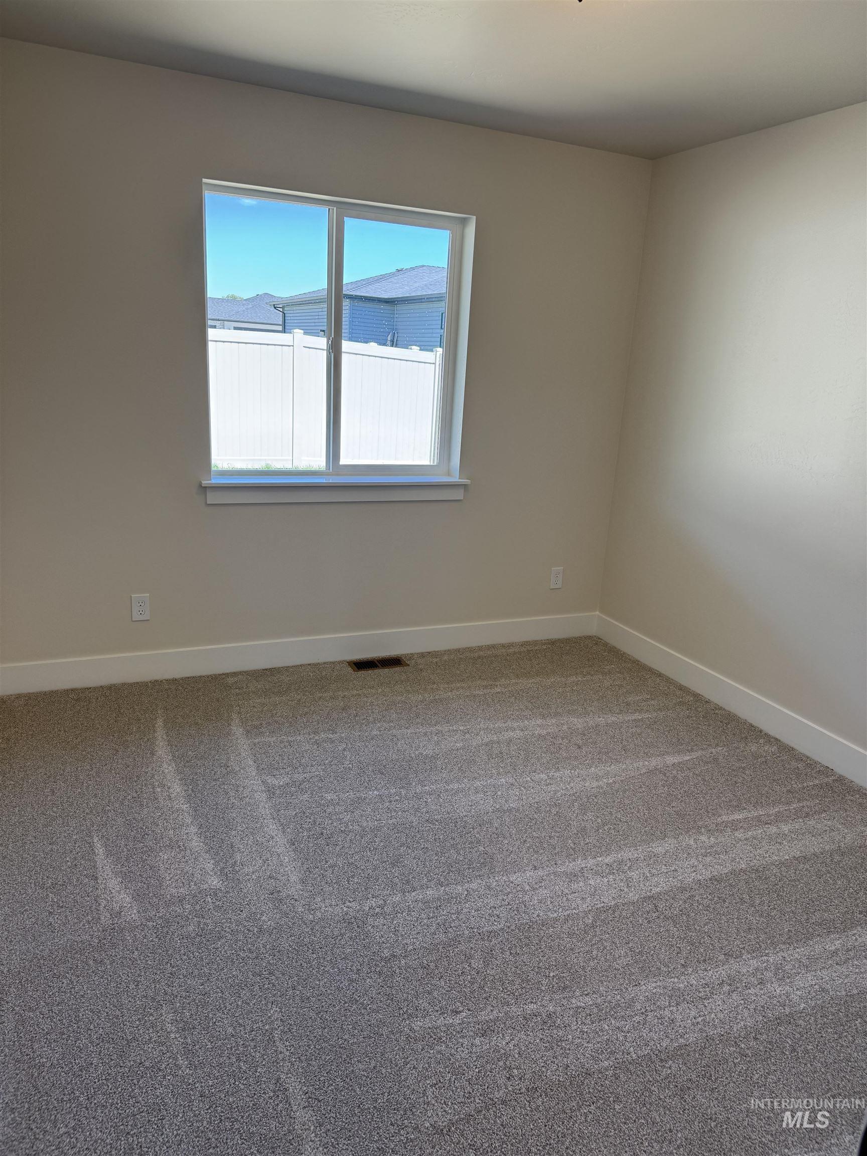 Carpeted spare room with baseboards