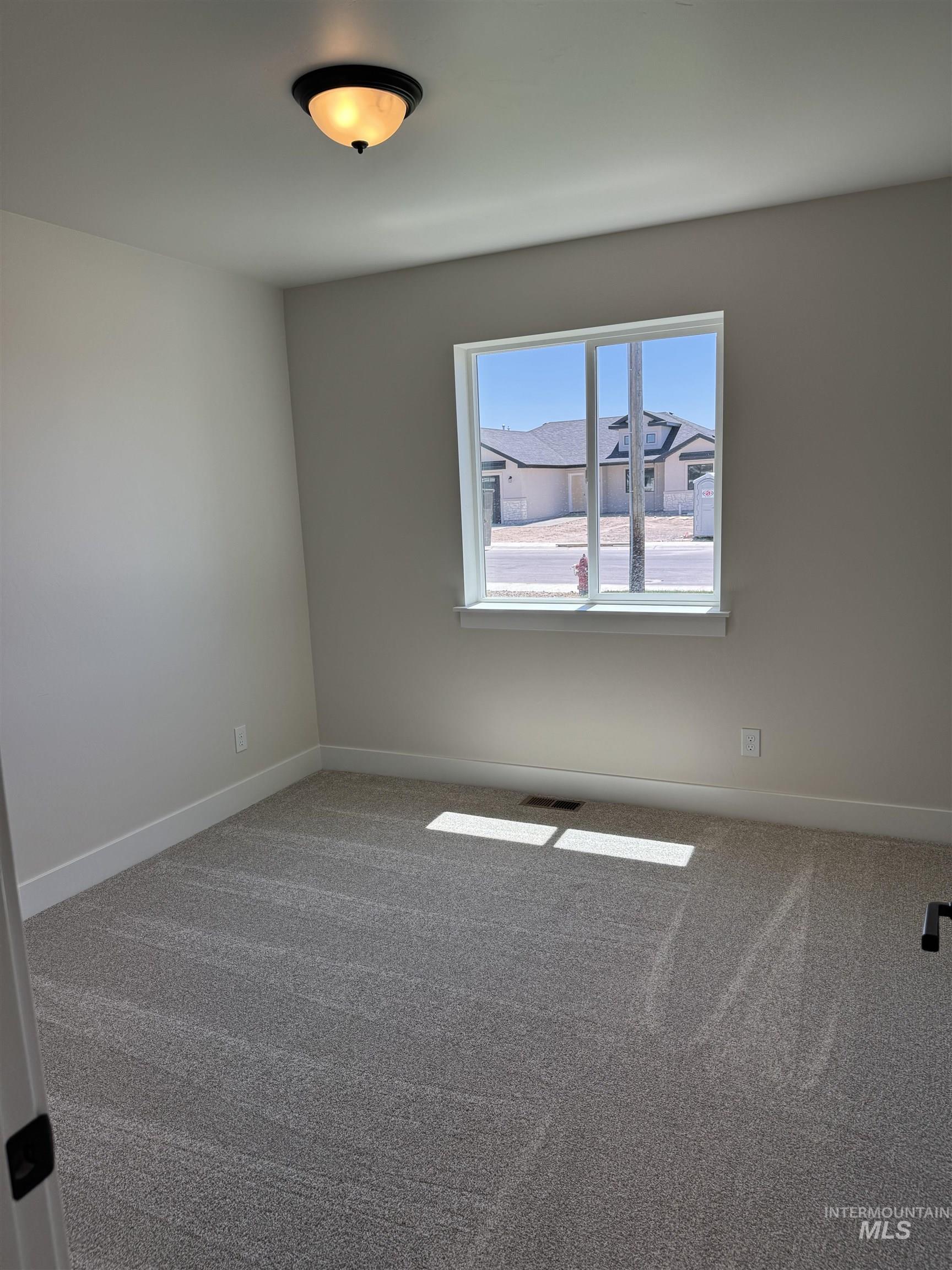 Carpeted empty room featuring baseboards