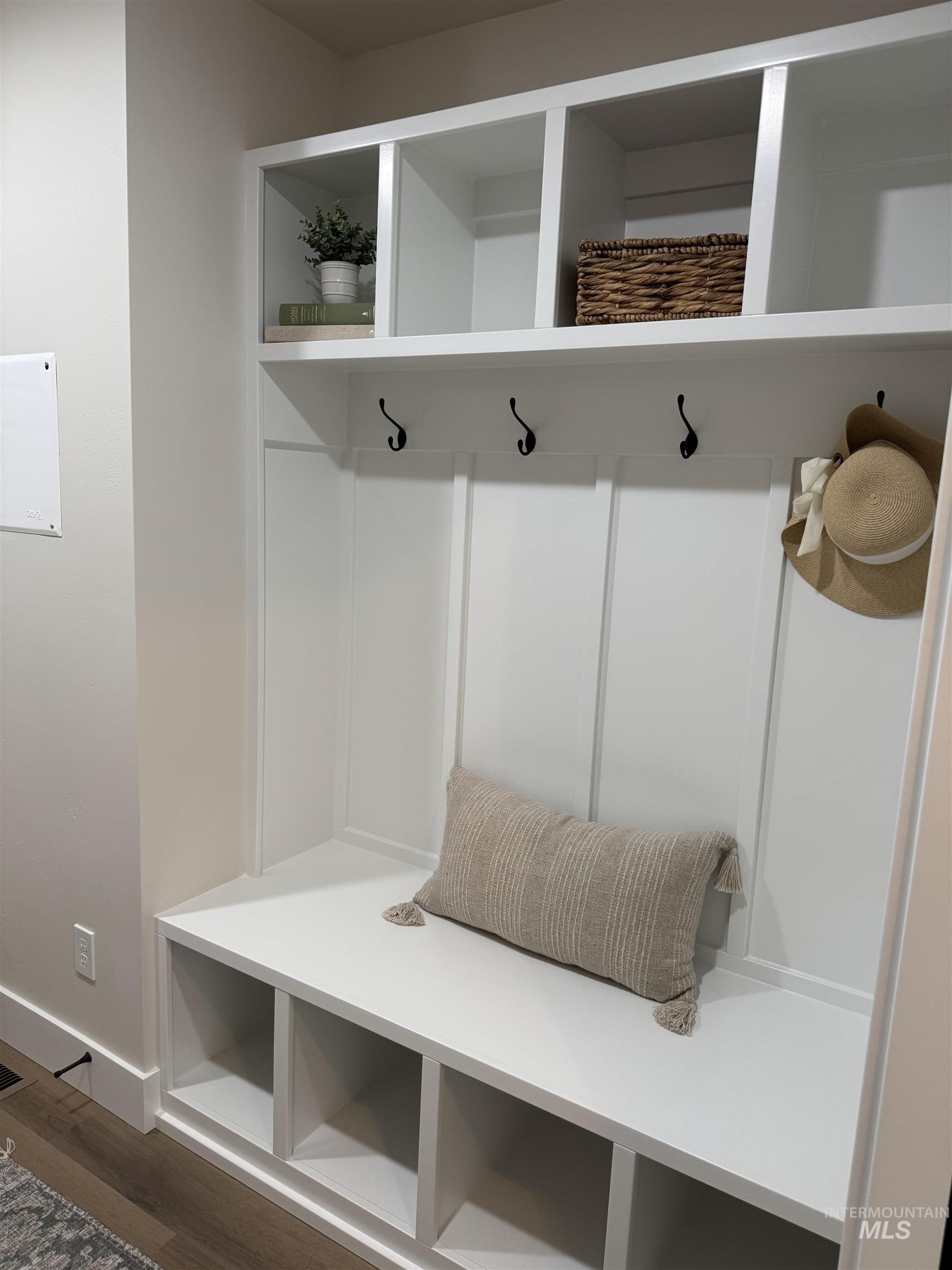 Mudroom featuring dark wood-style flooring and baseboards