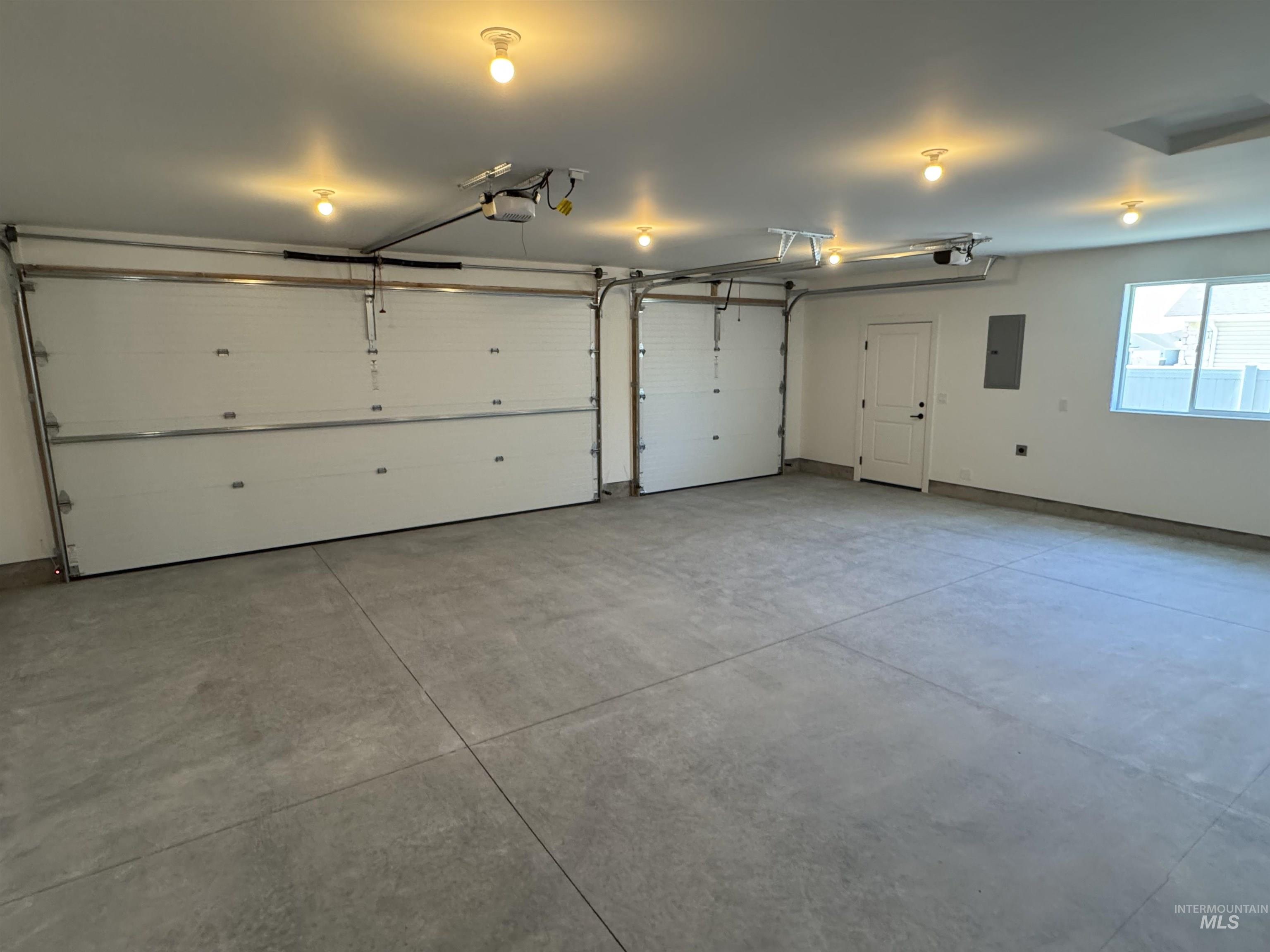 Garage featuring a garage door opener and electric panel