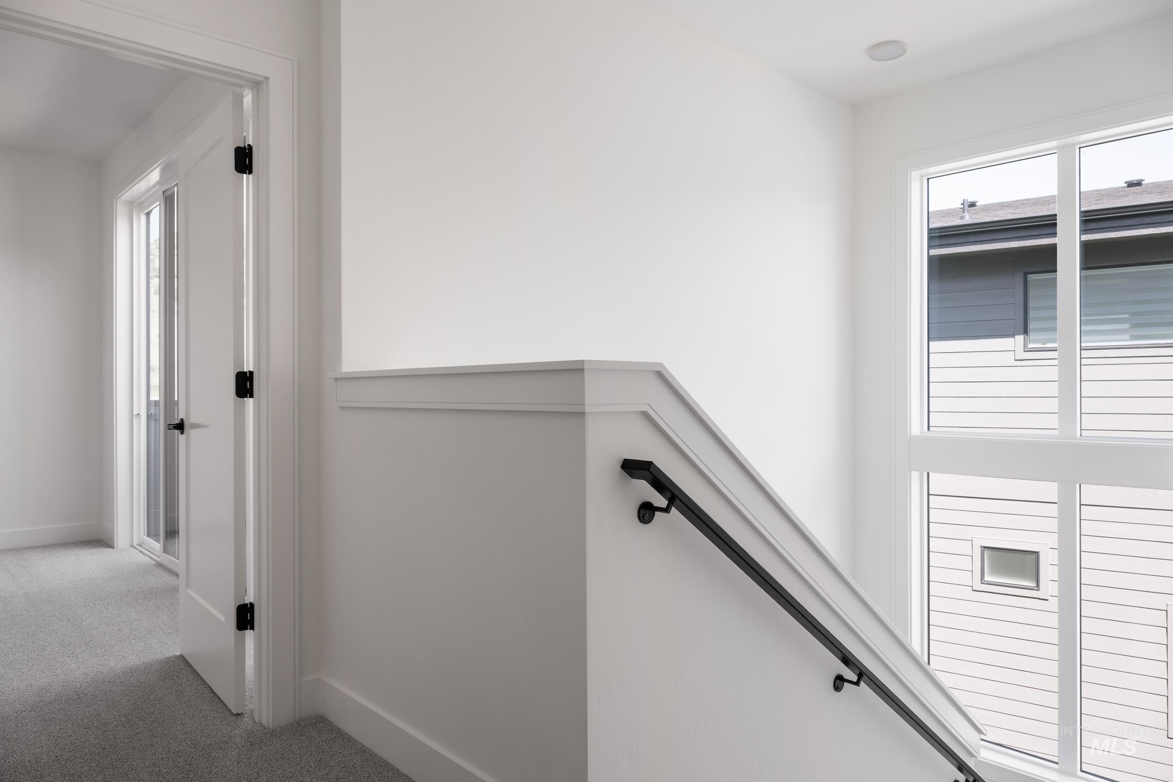 Hallway featuring carpet and baseboards