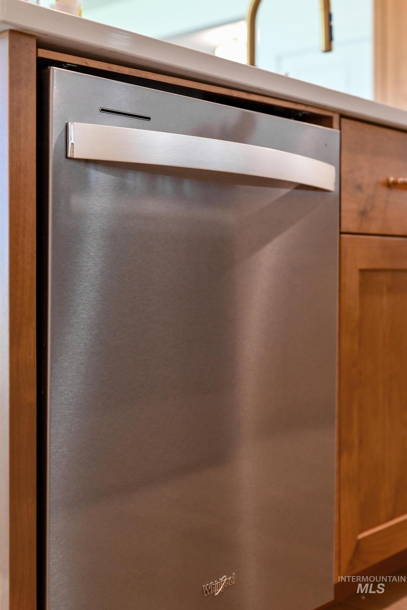 Kitchen view of dishwasher and light countertops