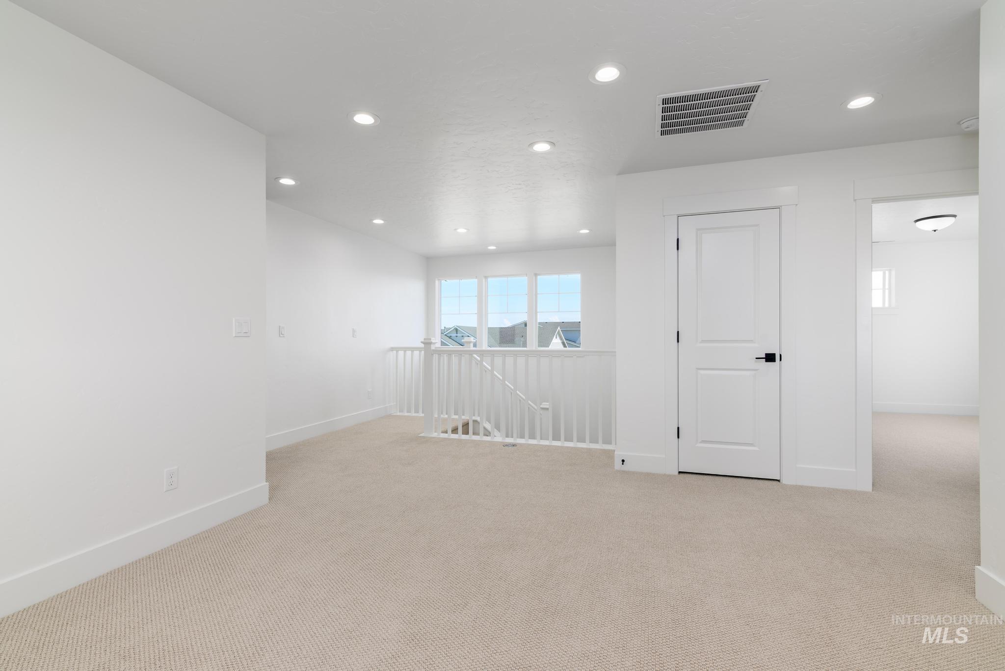 Empty room featuring light colored carpet and recessed lighting