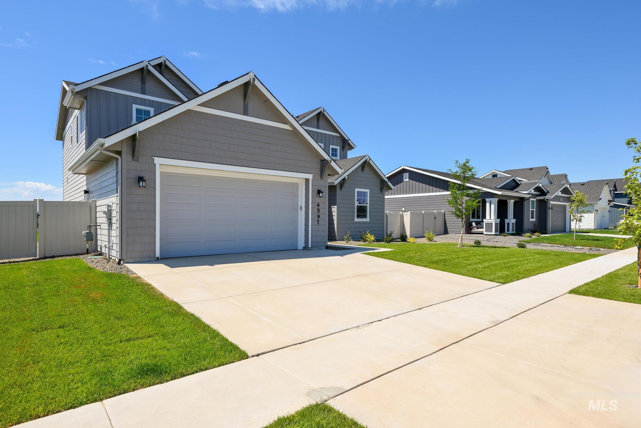 Craftsman-style house featuring driveway, an attached garage, a gate, and board and batten siding