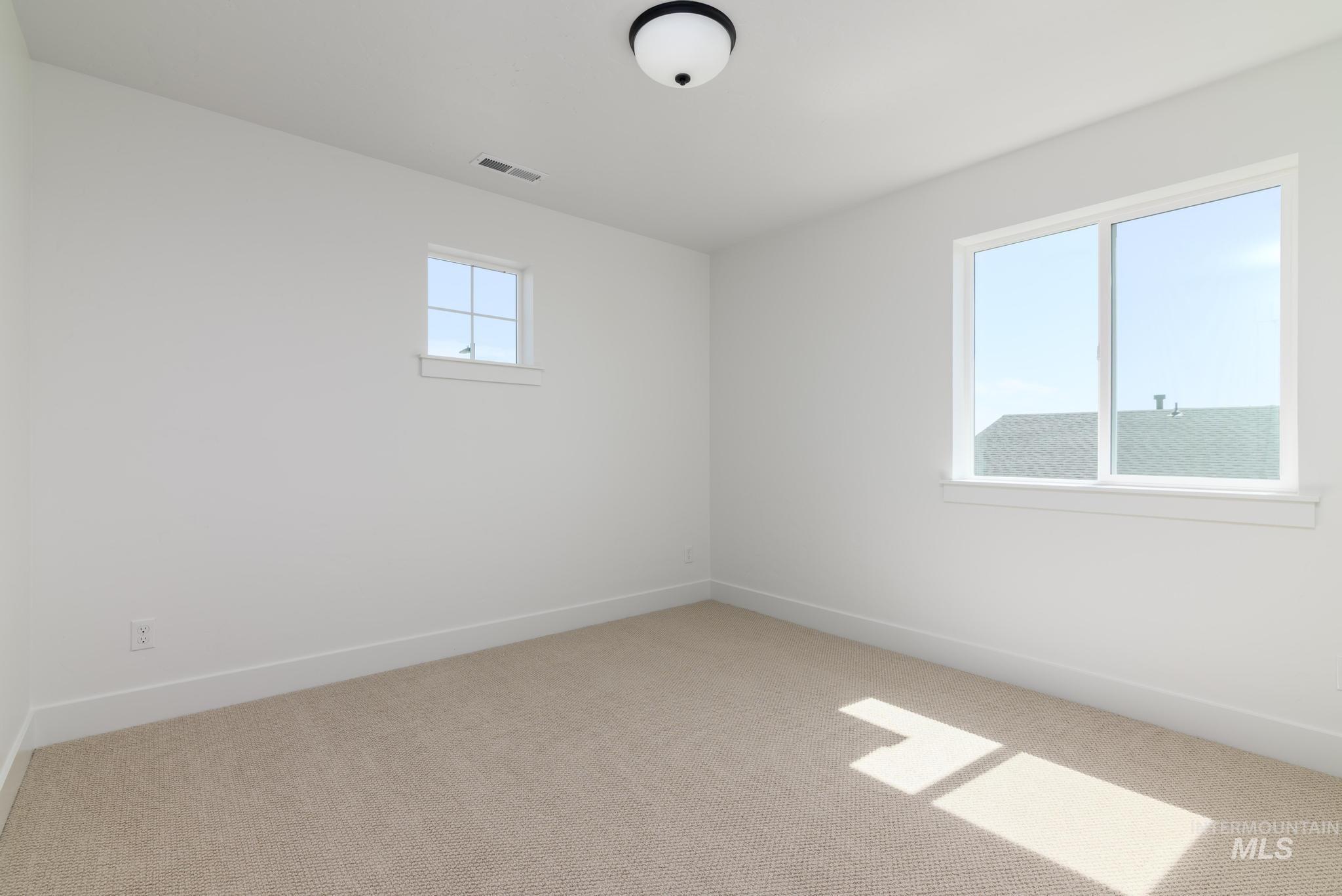 Spare room with carpet and baseboards