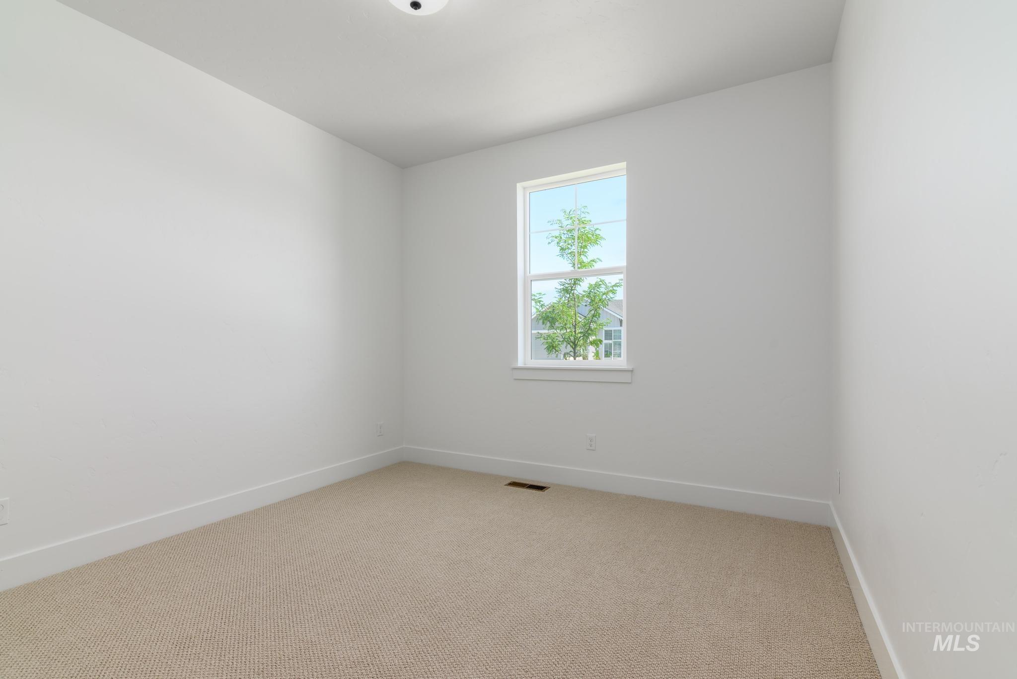 Spare room with light carpet and baseboards
