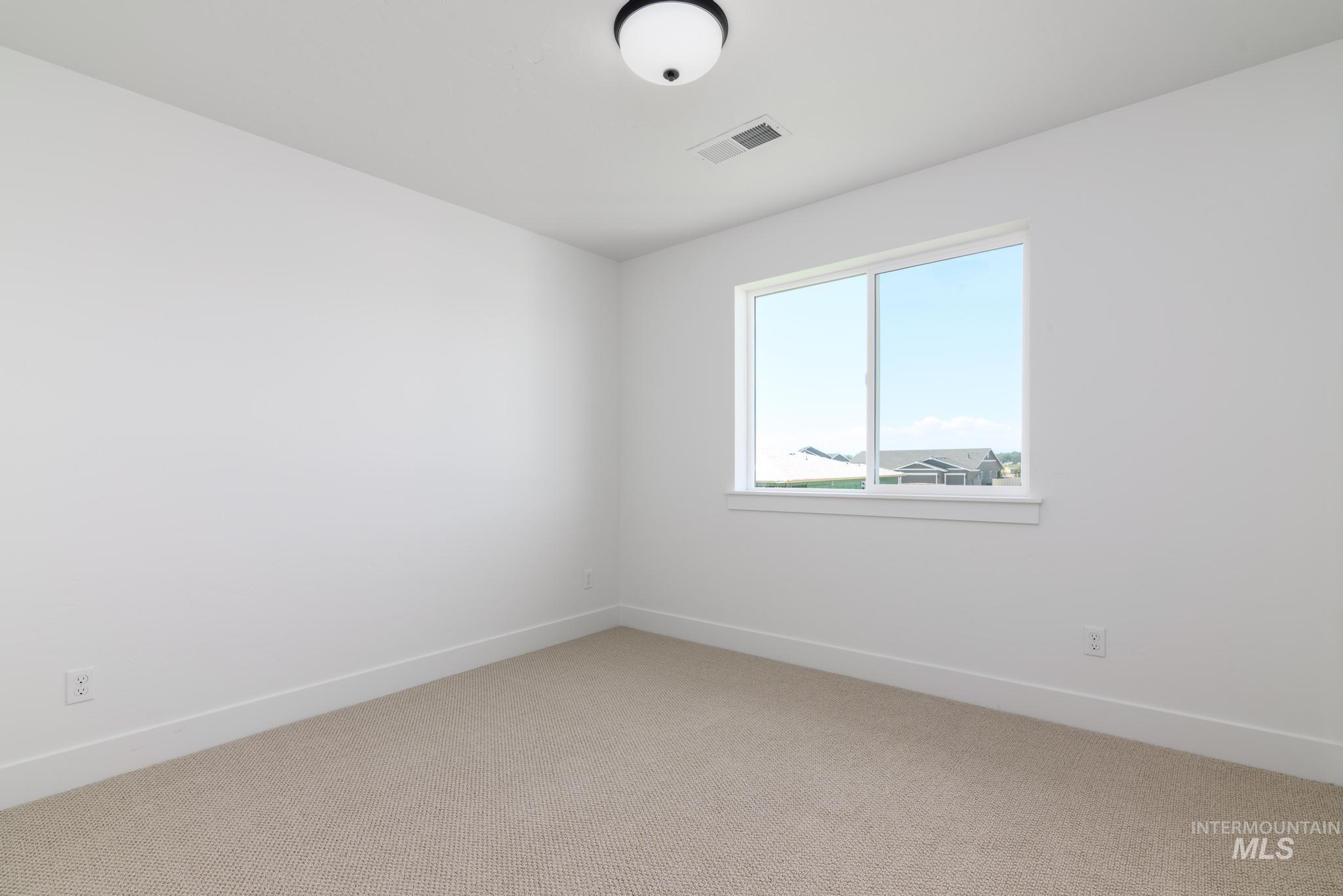 Empty room with light carpet and baseboards