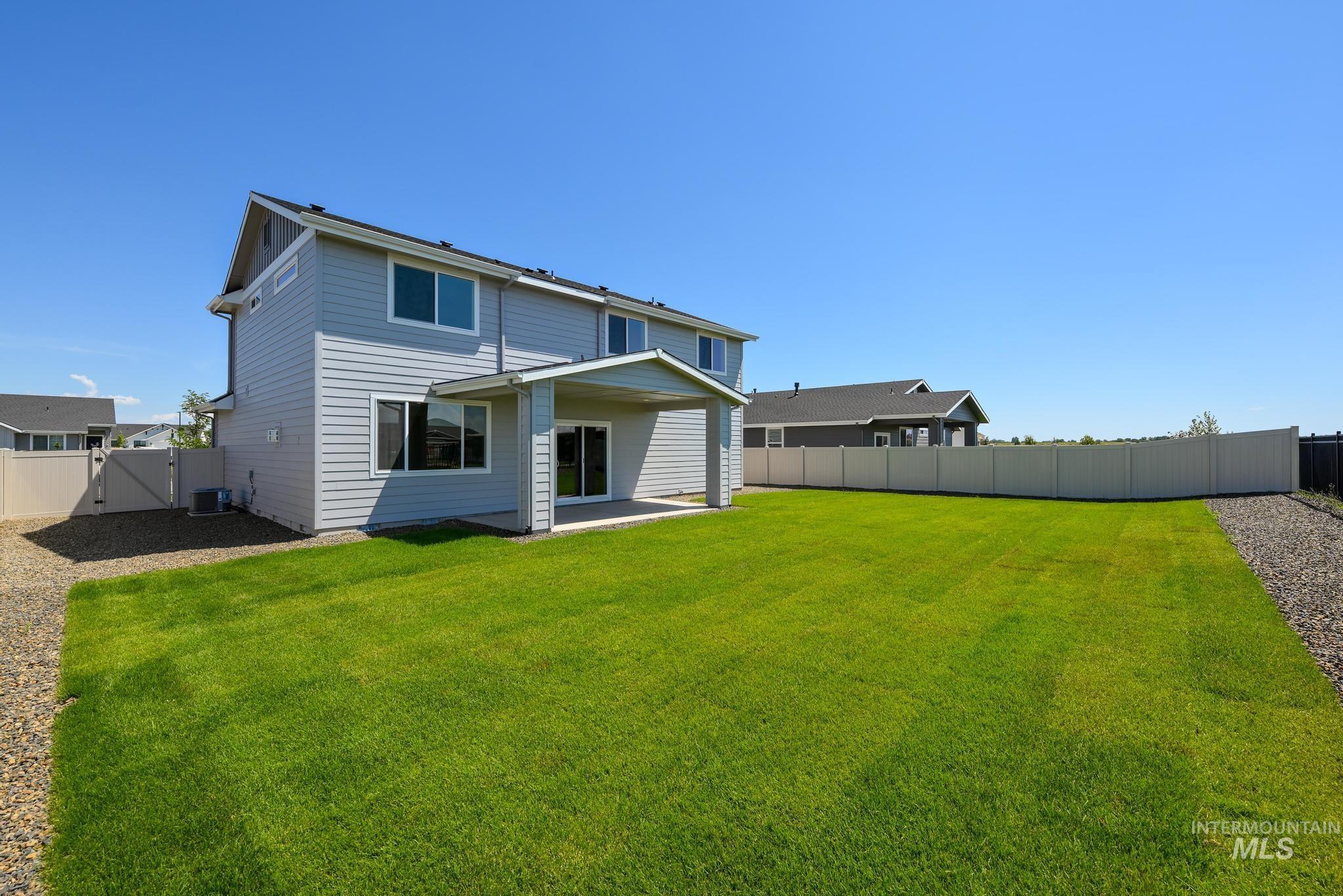 Back of property featuring a fenced backyard, a patio, and a gate