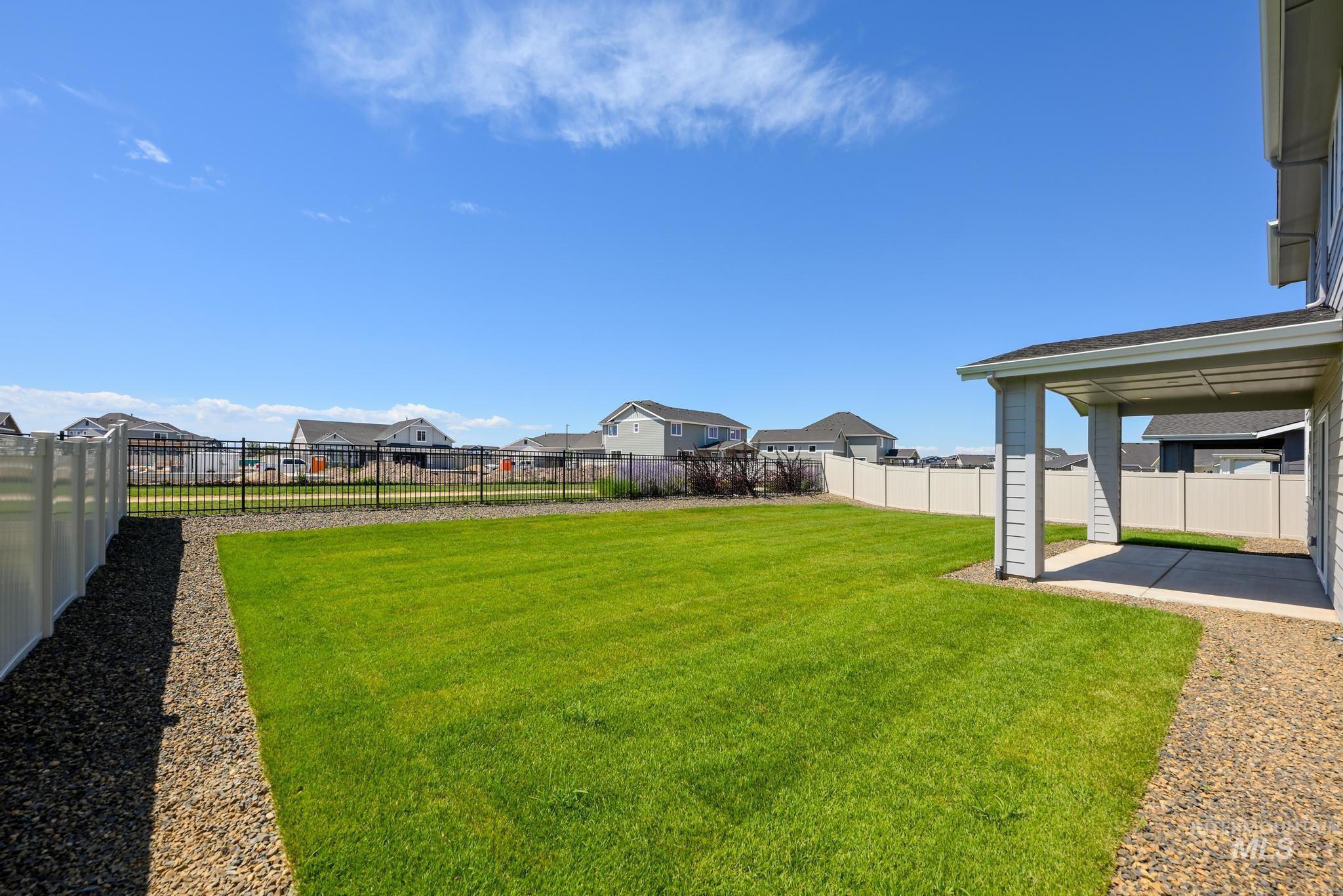Fenced backyard with a residential view and a patio area