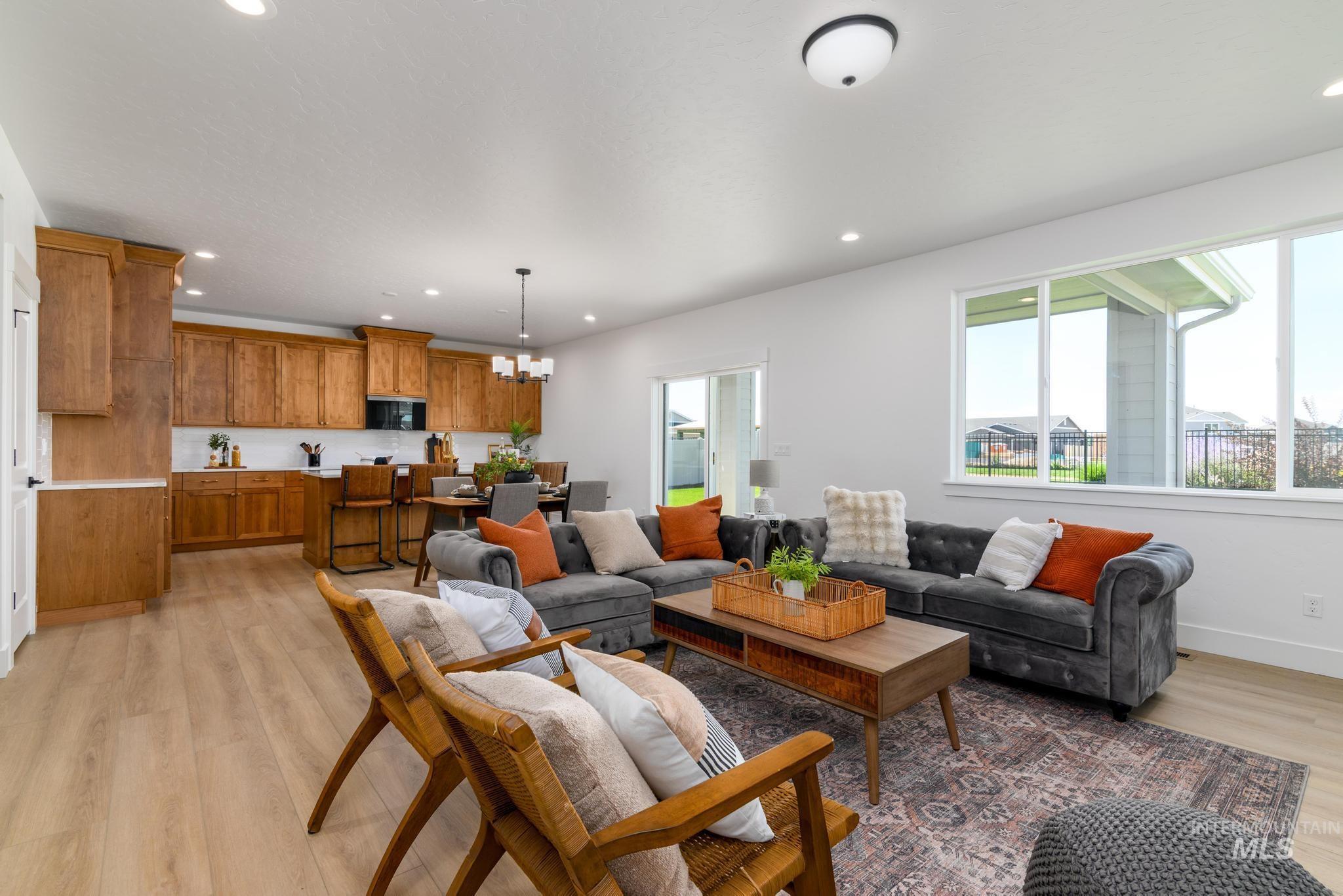 Living area featuring light wood-style floors, a chandelier, and recessed lighting