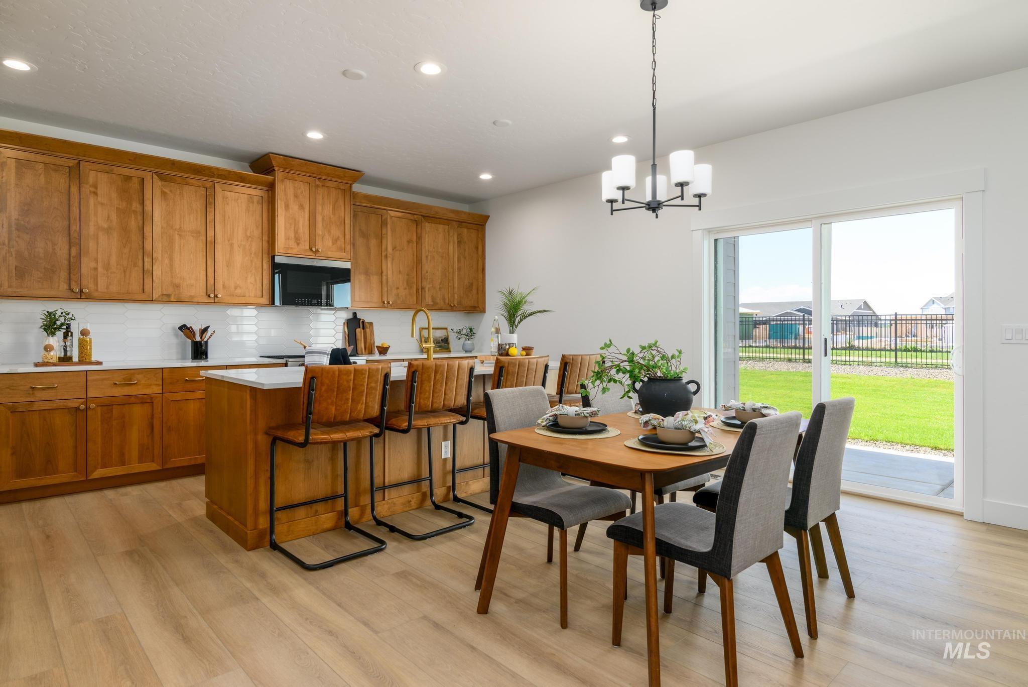 Dining room with light wood-style floors, a chandelier, and recessed lighting