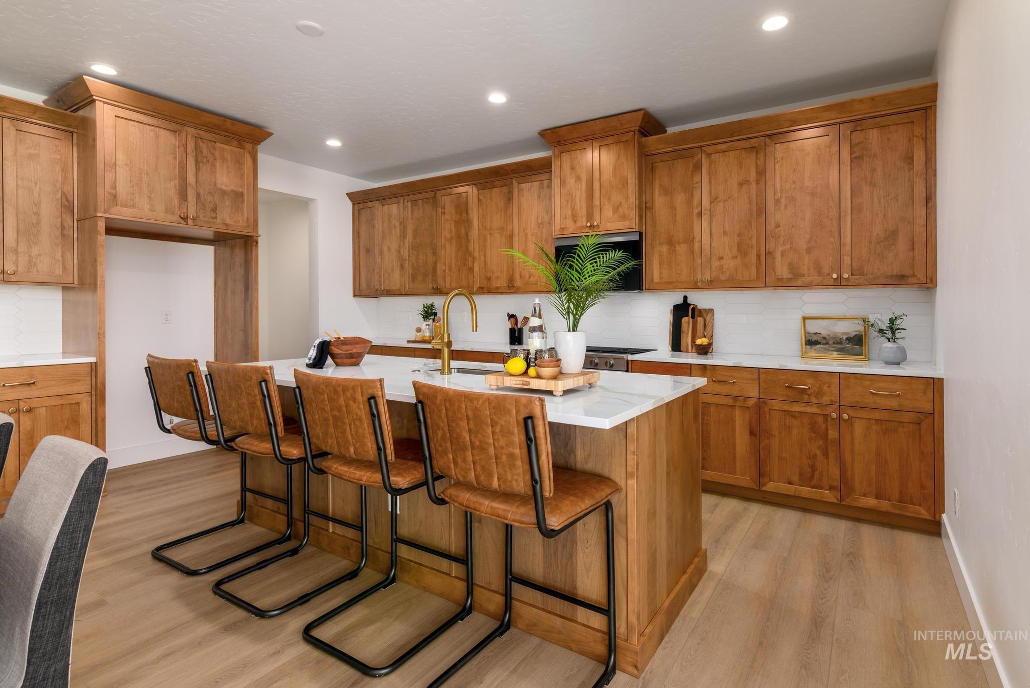 Kitchen featuring tasteful backsplash, brown cabinets, light wood-type flooring, and recessed lighting