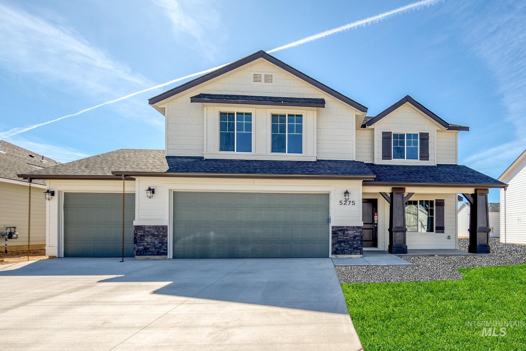 Craftsman house featuring roof with shingles, driveway, stone siding, covered porch, and a garage