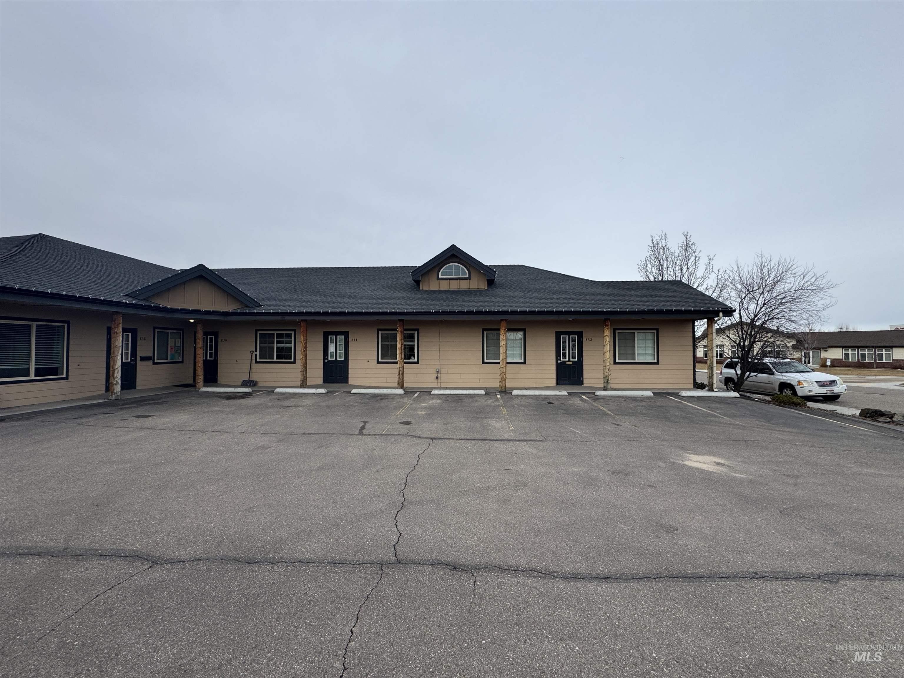 View of building exterior featuring uncovered parking