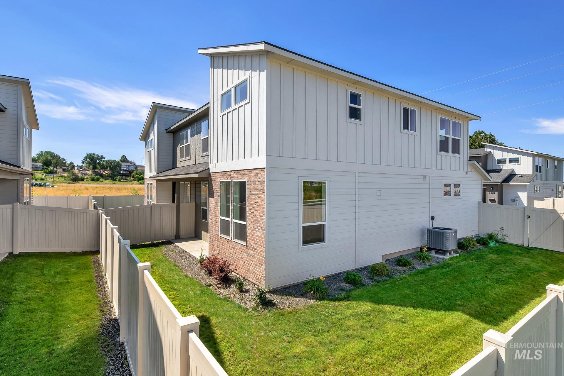 View of property exterior featuring a fenced backyard, board and batten siding, and brick siding