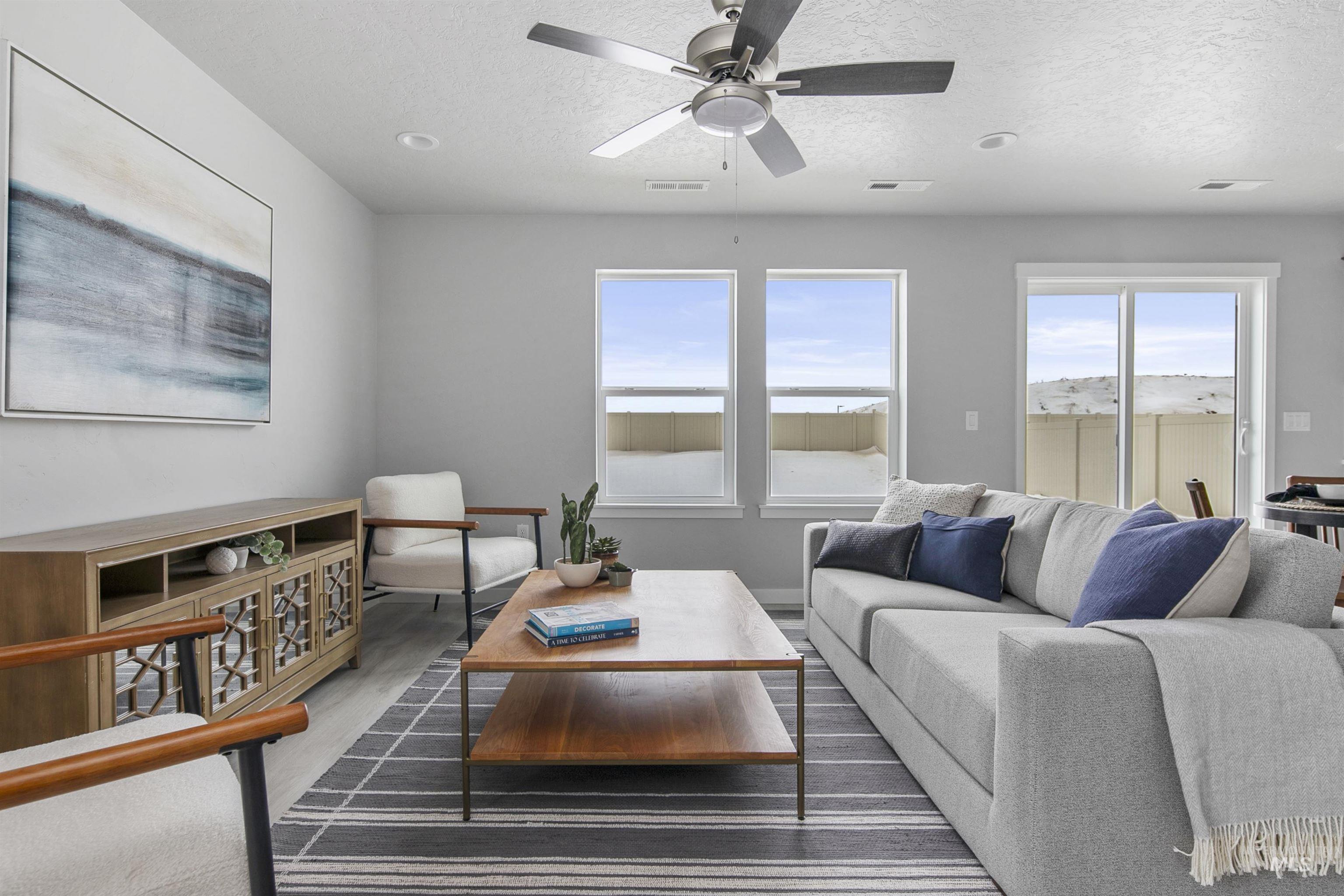 Living room with a textured ceiling, wood finished floors, and a ceiling fan