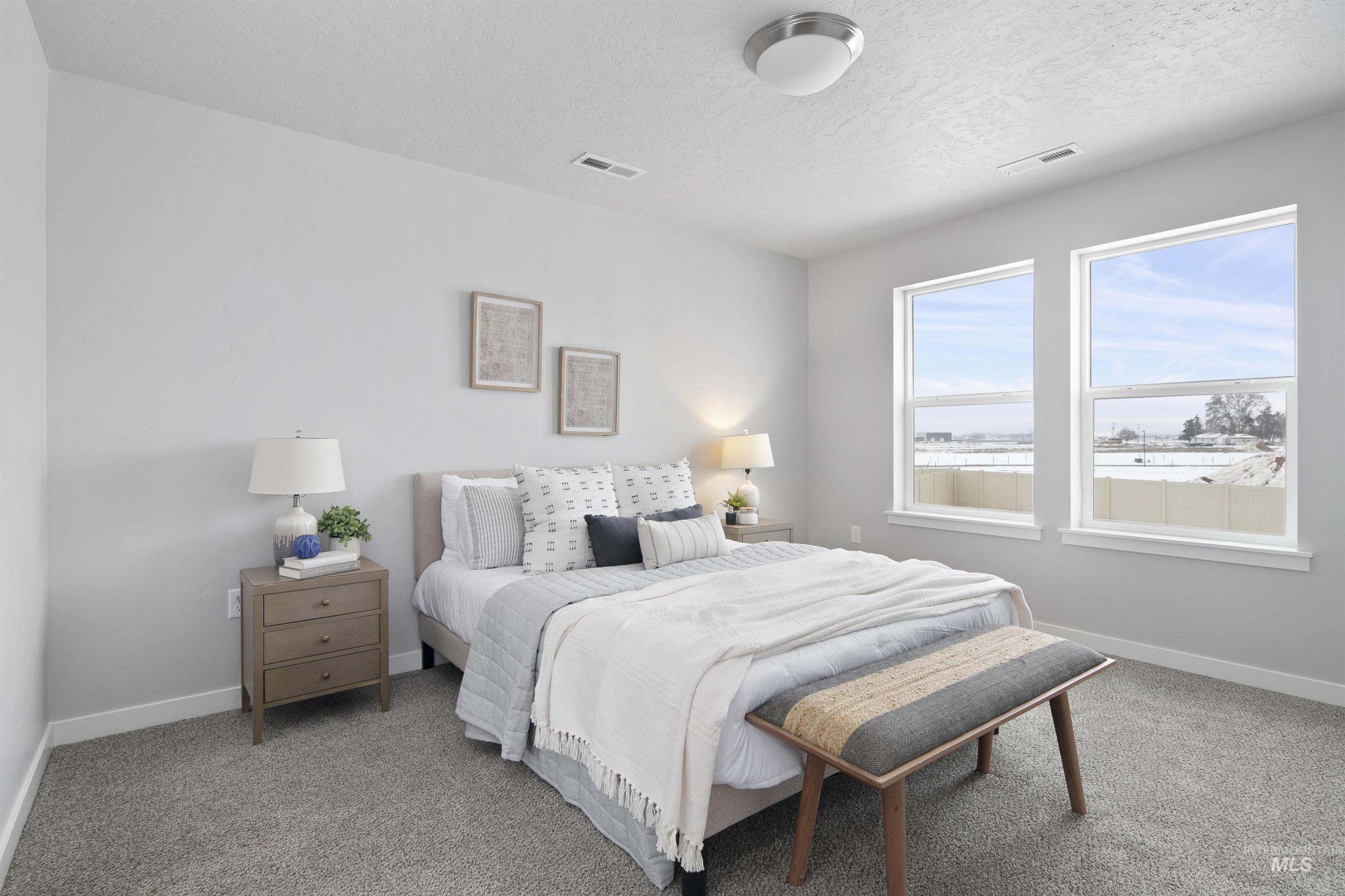 Carpeted bedroom featuring baseboards and a textured ceiling