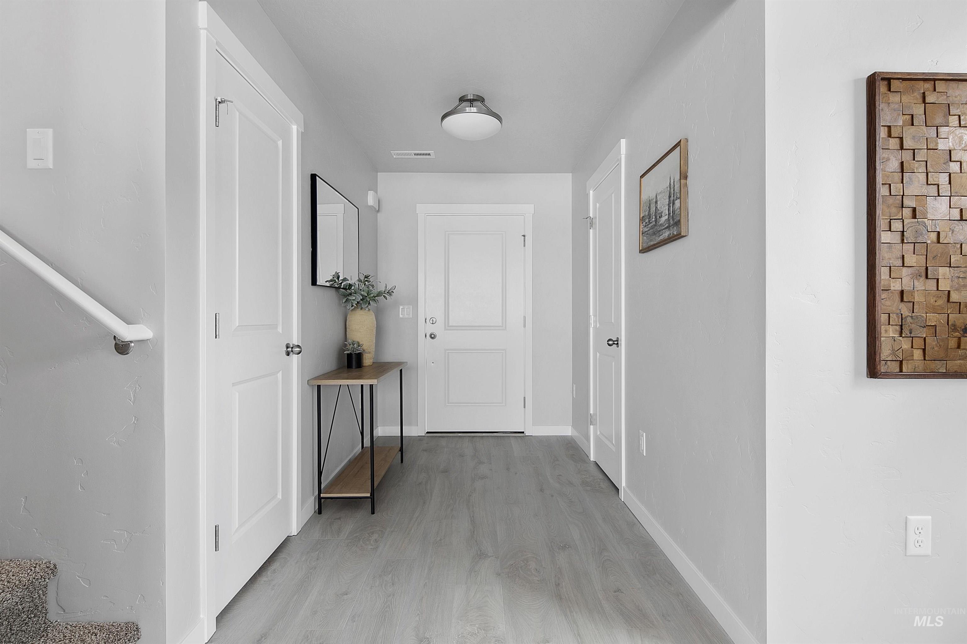 Corridor with light wood-style floors and baseboards