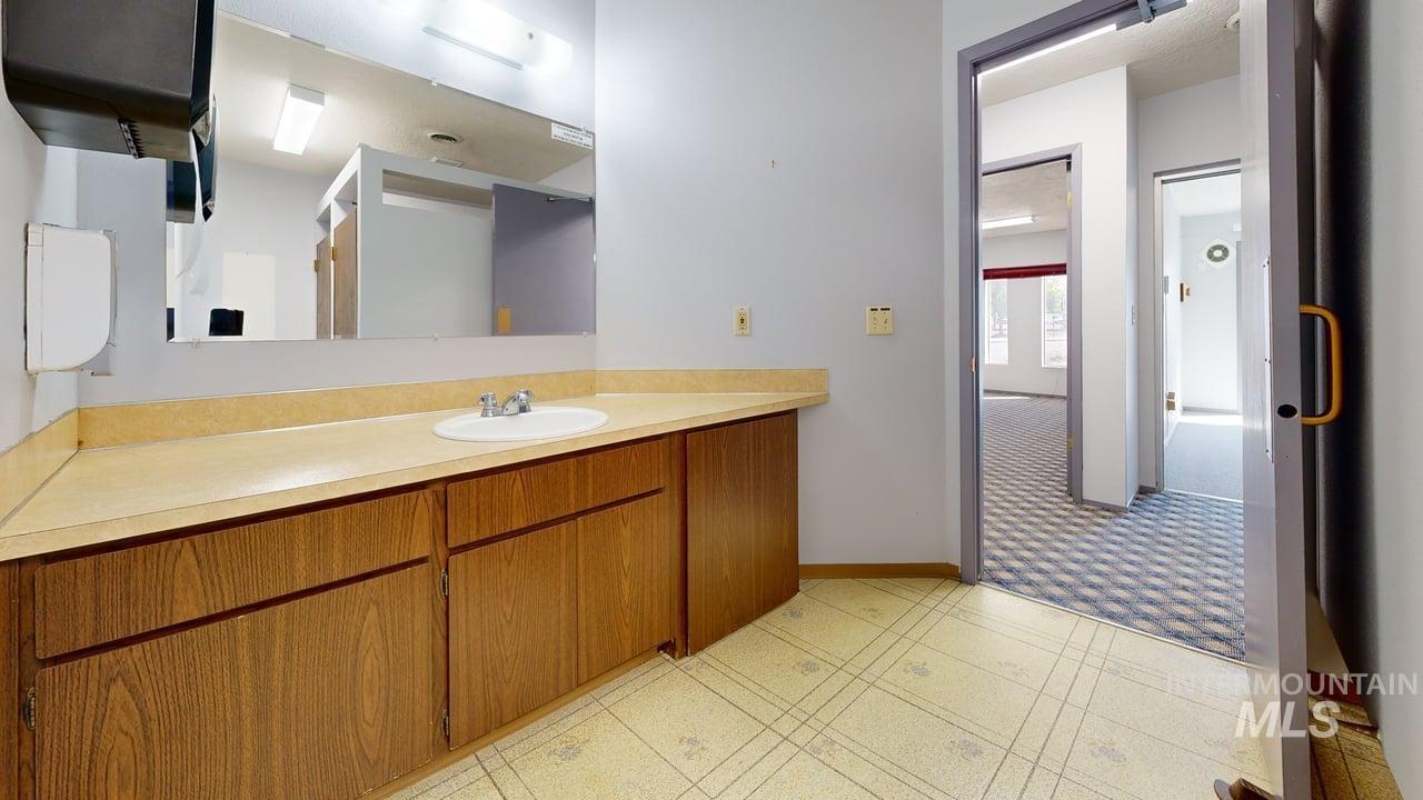 Bathroom with vanity and light flooring