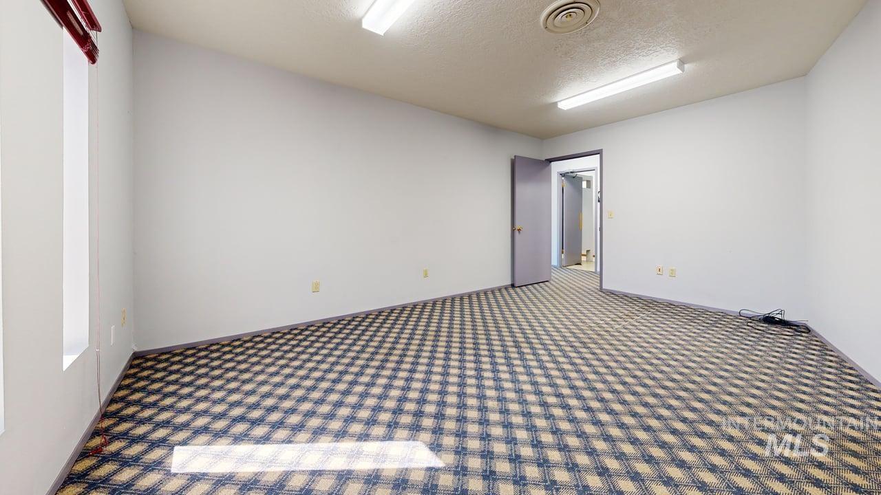Empty room featuring a textured ceiling and carpet flooring