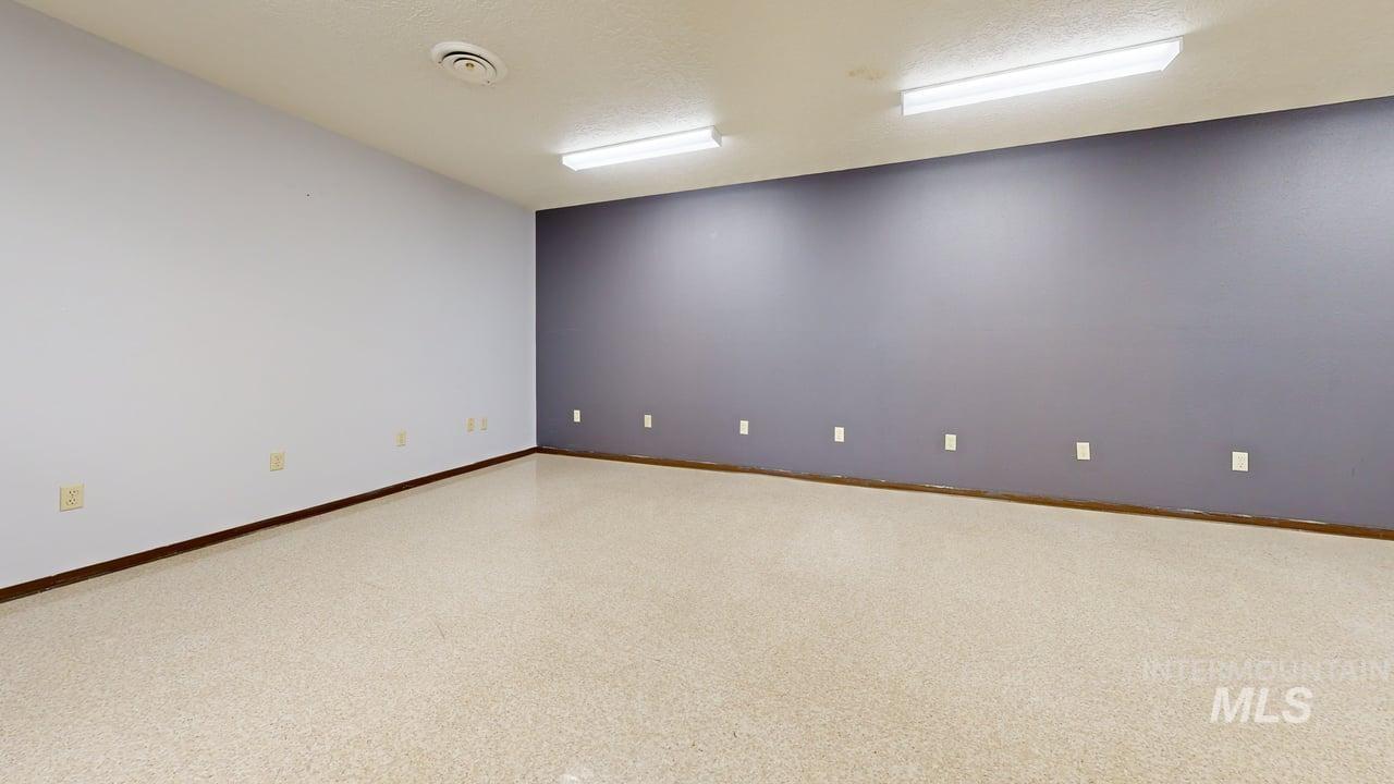 Unfurnished room featuring a textured ceiling and baseboards