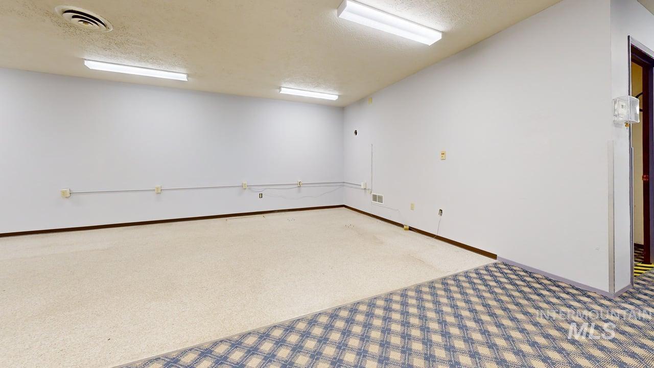Carpeted spare room featuring a textured ceiling