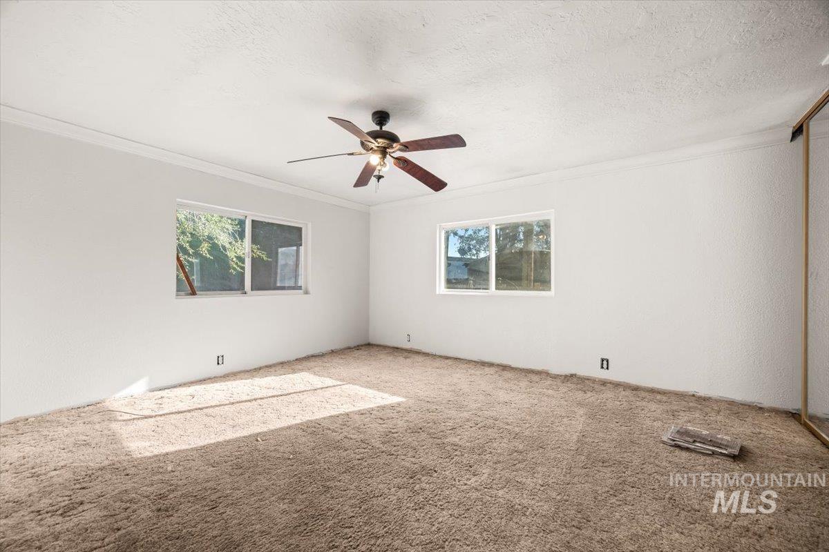 Master Bedroom featuring carpet floors, crown molding, a textured ceiling, and ceiling fan