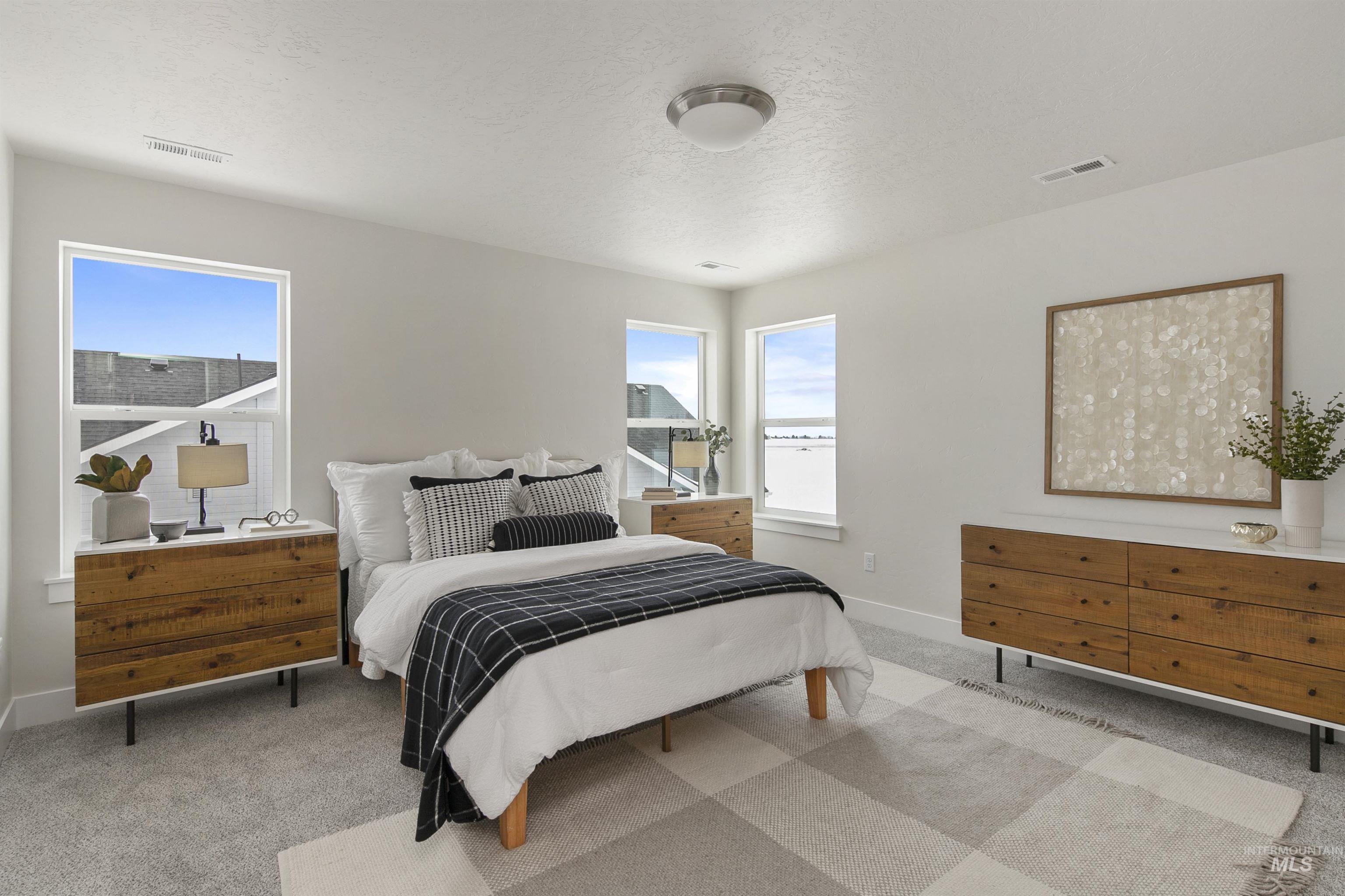 Bedroom featuring light colored carpet and a textured ceiling