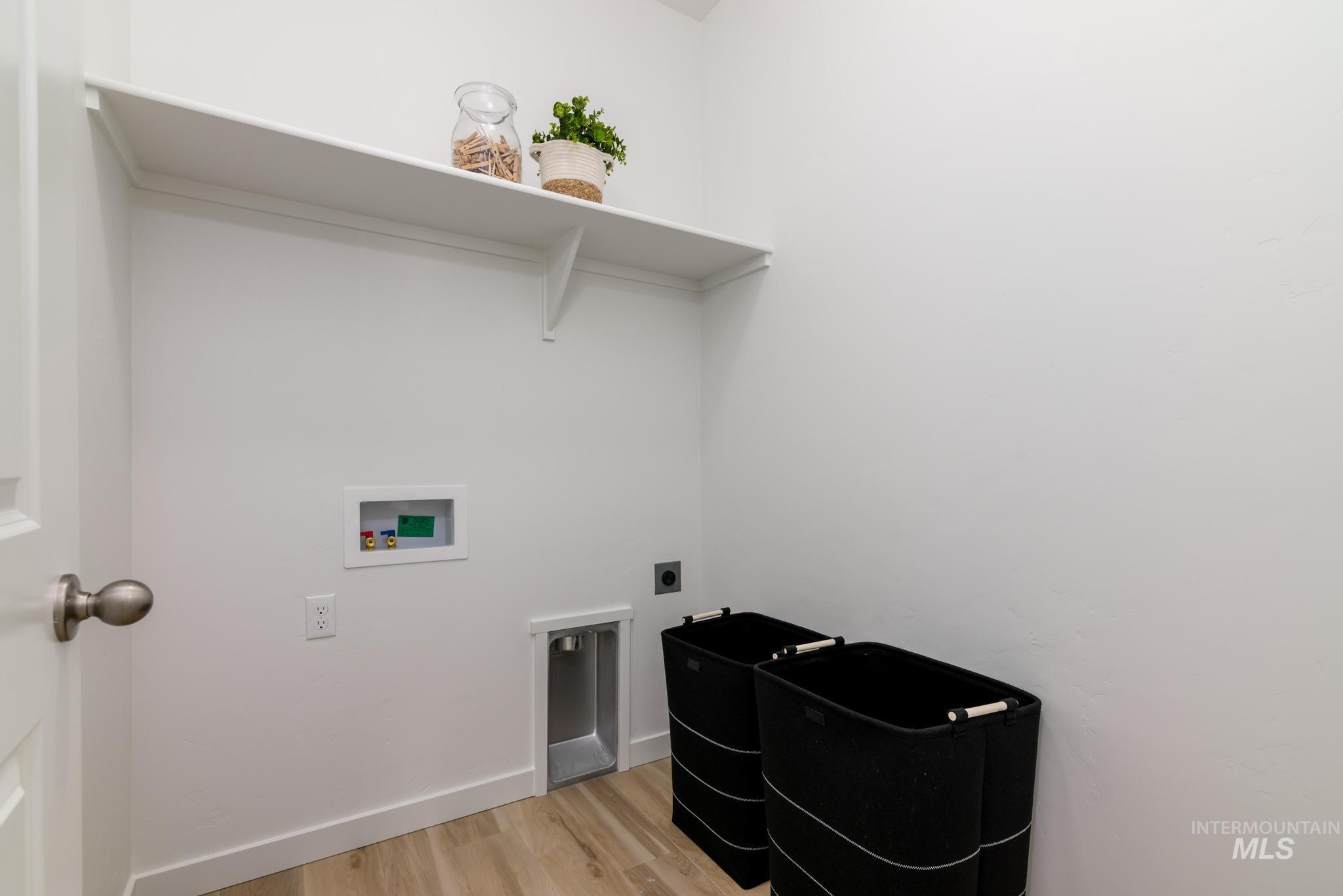 Washroom with light wood-style floors, hookup for an electric dryer, and hookup for a washing machine