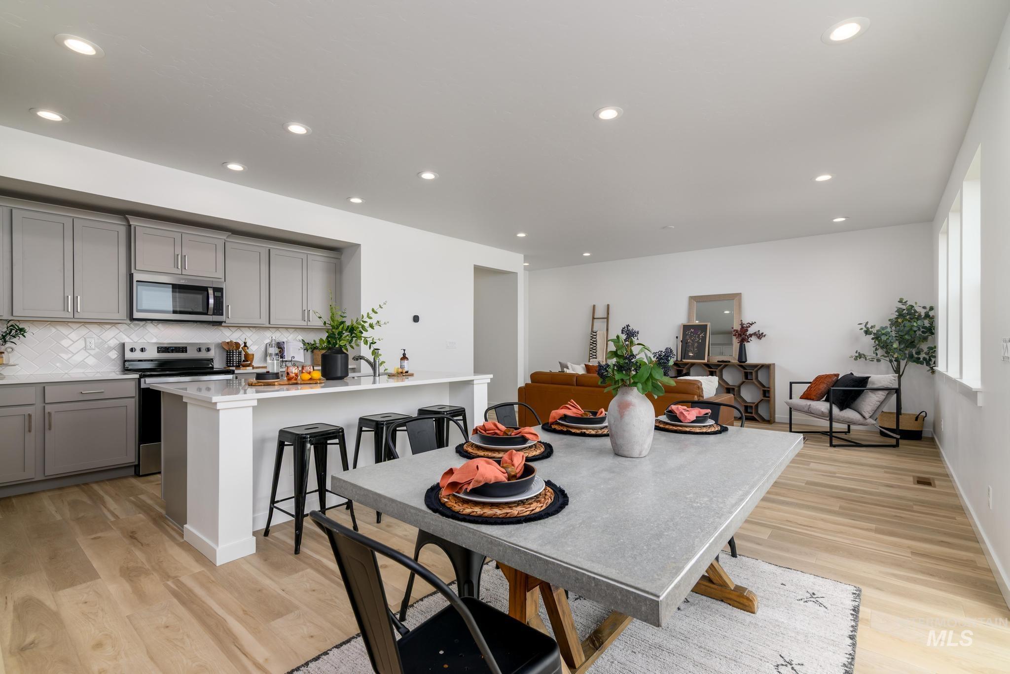 Dining space with light wood-style floors and recessed lighting