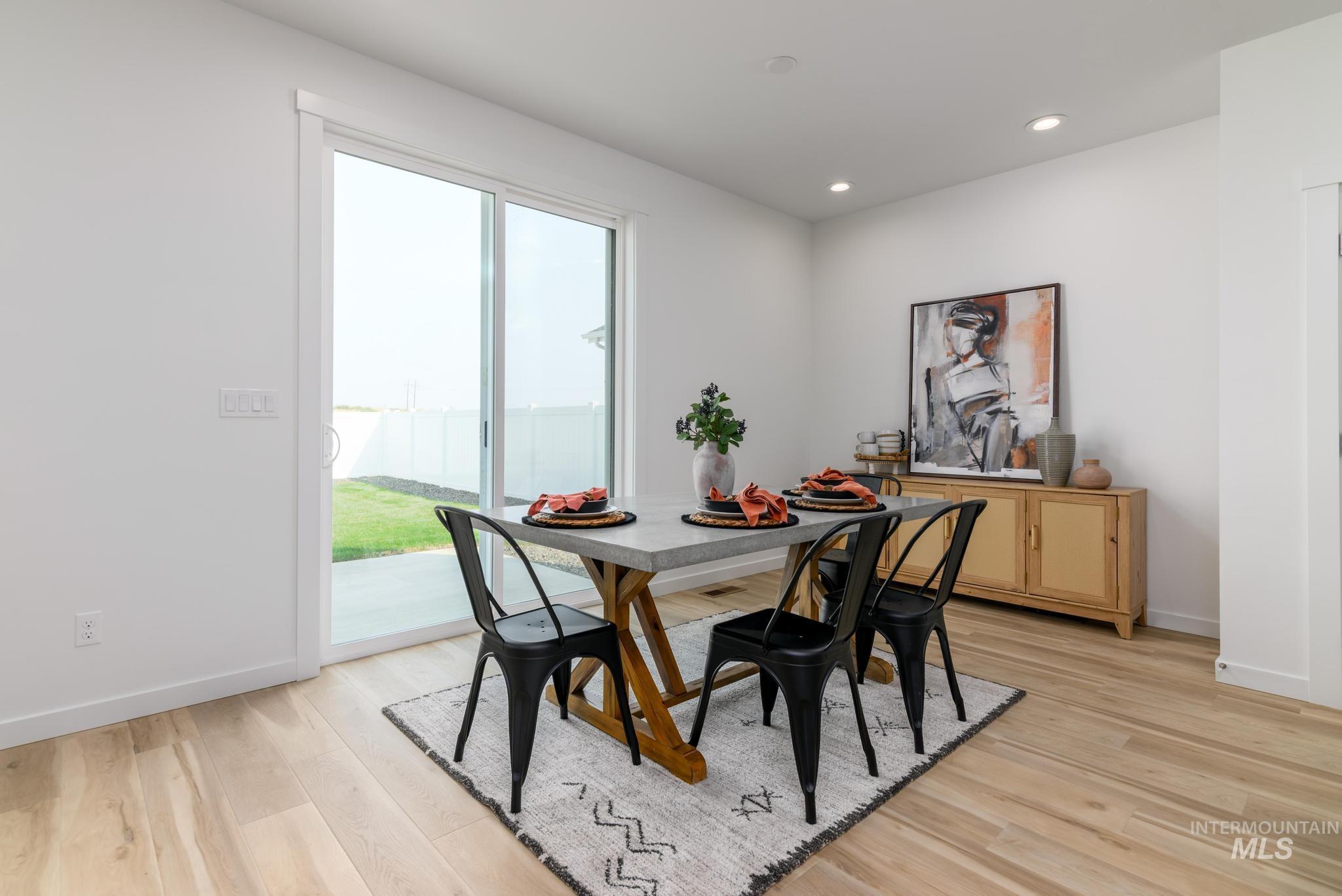 Dining area with light wood-style floors and recessed lighting
