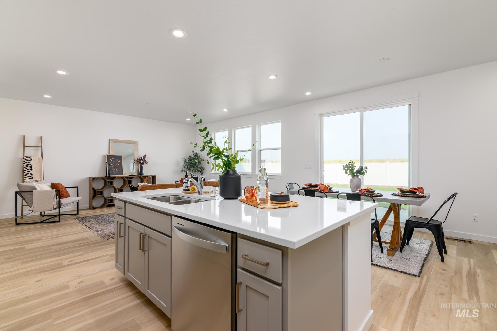 Kitchen with dishwasher, gray cabinets, recessed lighting, a kitchen island with sink, and light wood-style floors