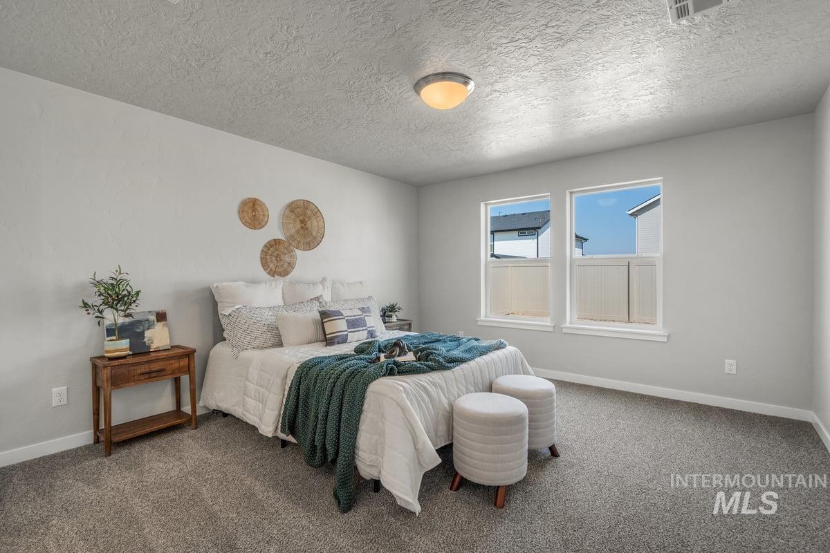 Bedroom featuring carpet and a textured ceiling