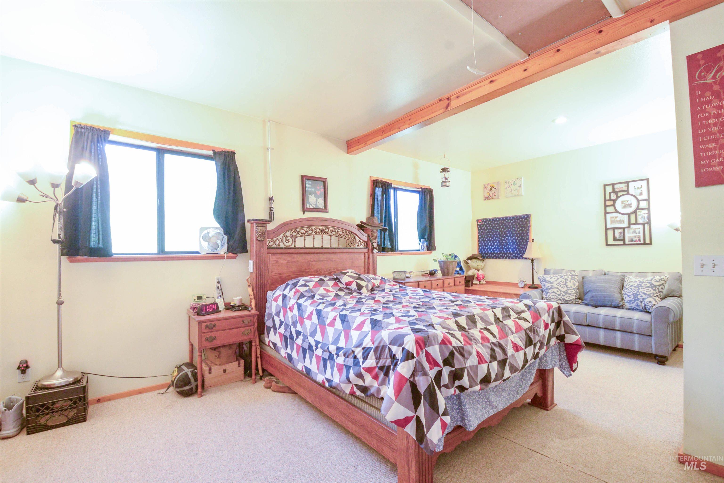 Bedroom featuring beam ceiling and carpet