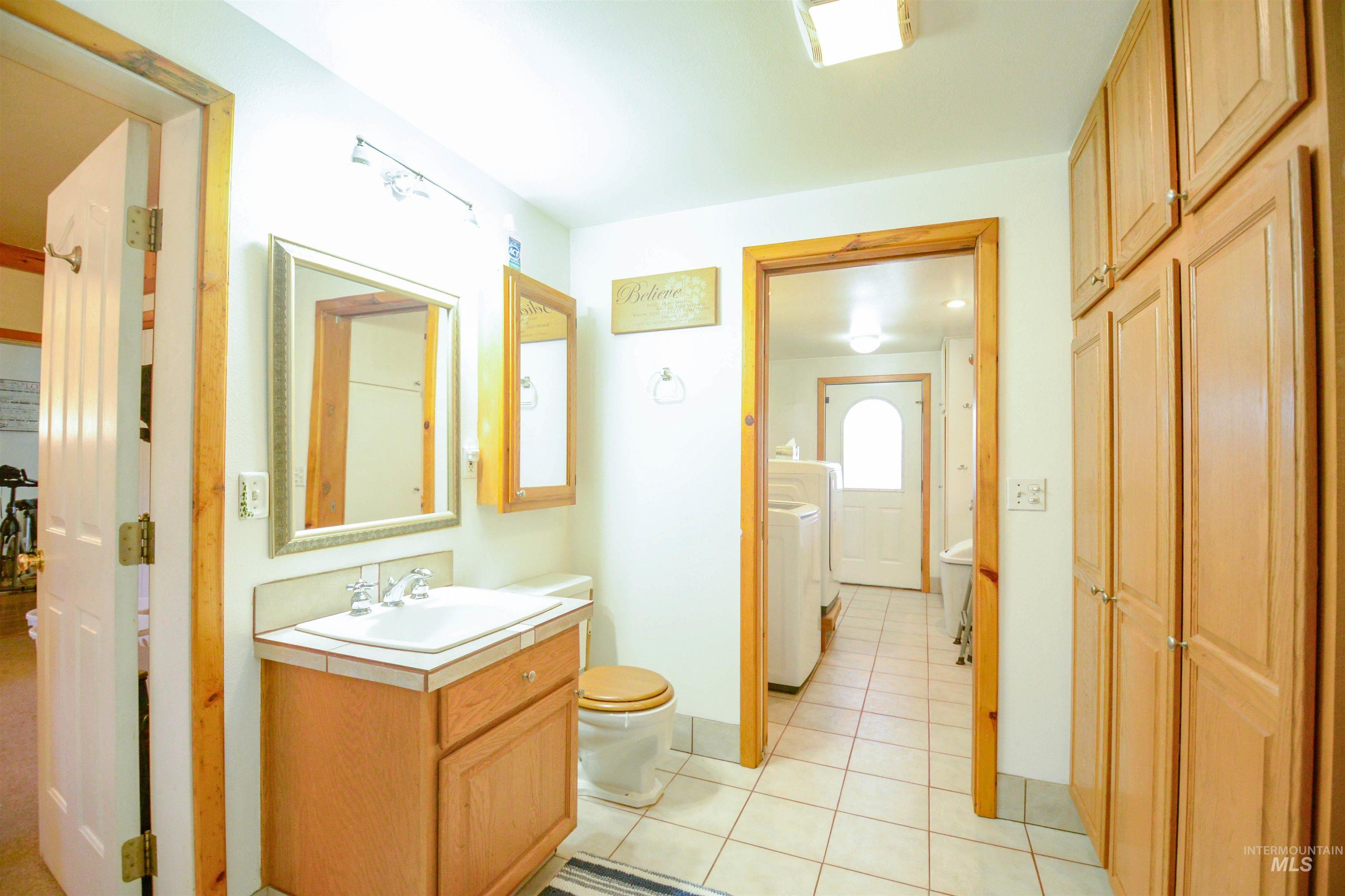 Bathroom with vanity, light tile patterned floors, and washer and clothes dryer