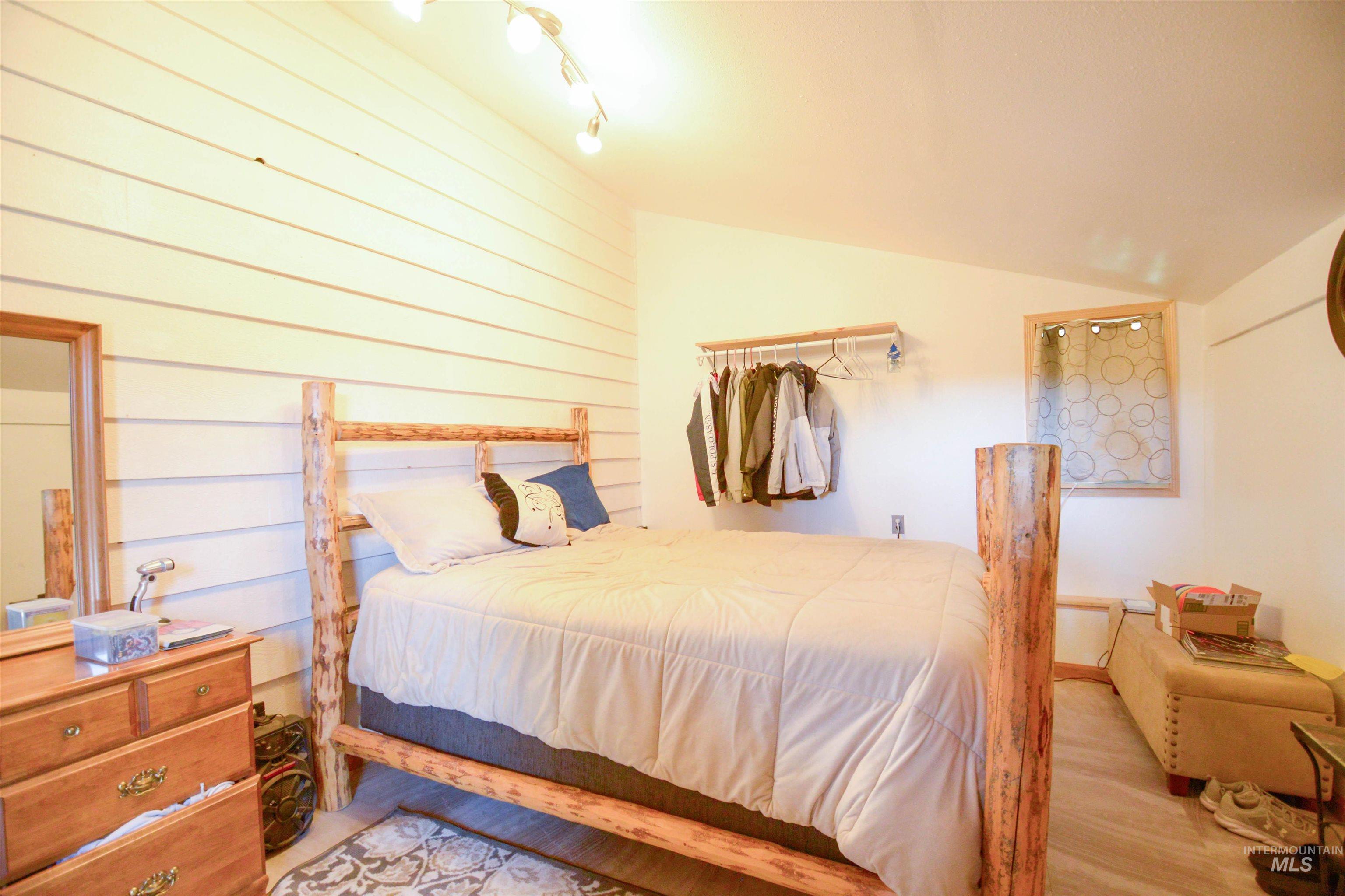 Bedroom with vaulted ceiling and light wood finished floors