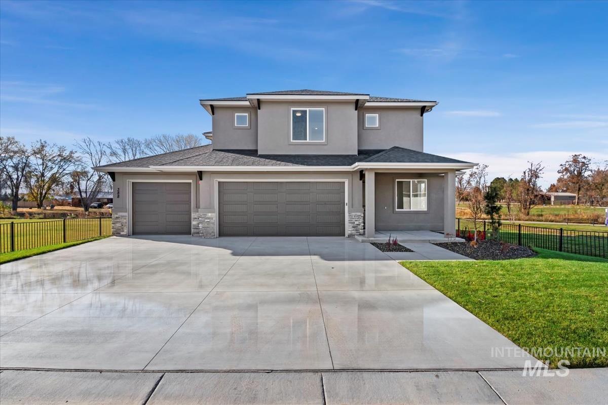 View of front of property featuring stucco siding, driveway, a shingled roof, and stone siding
