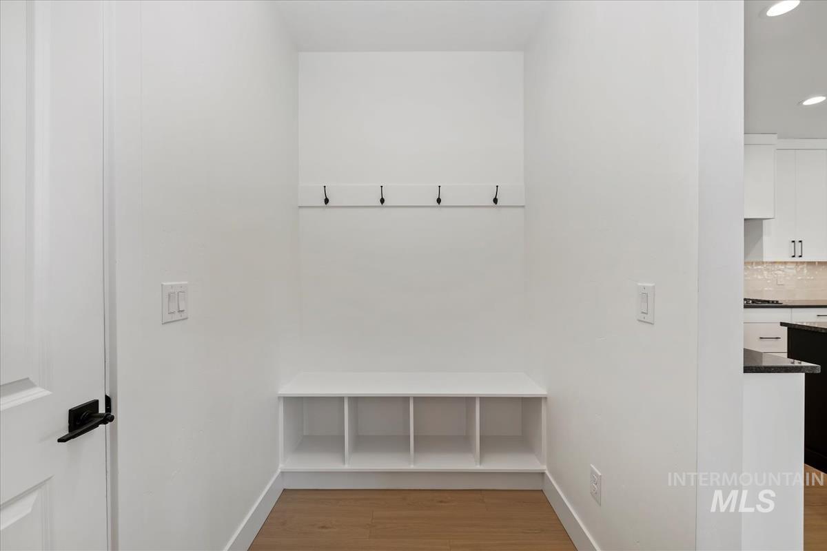 Mudroom featuring light wood finished floors and baseboards
