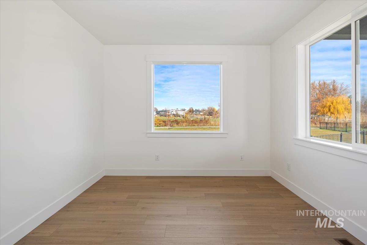 Empty room with light wood-style flooring and baseboards