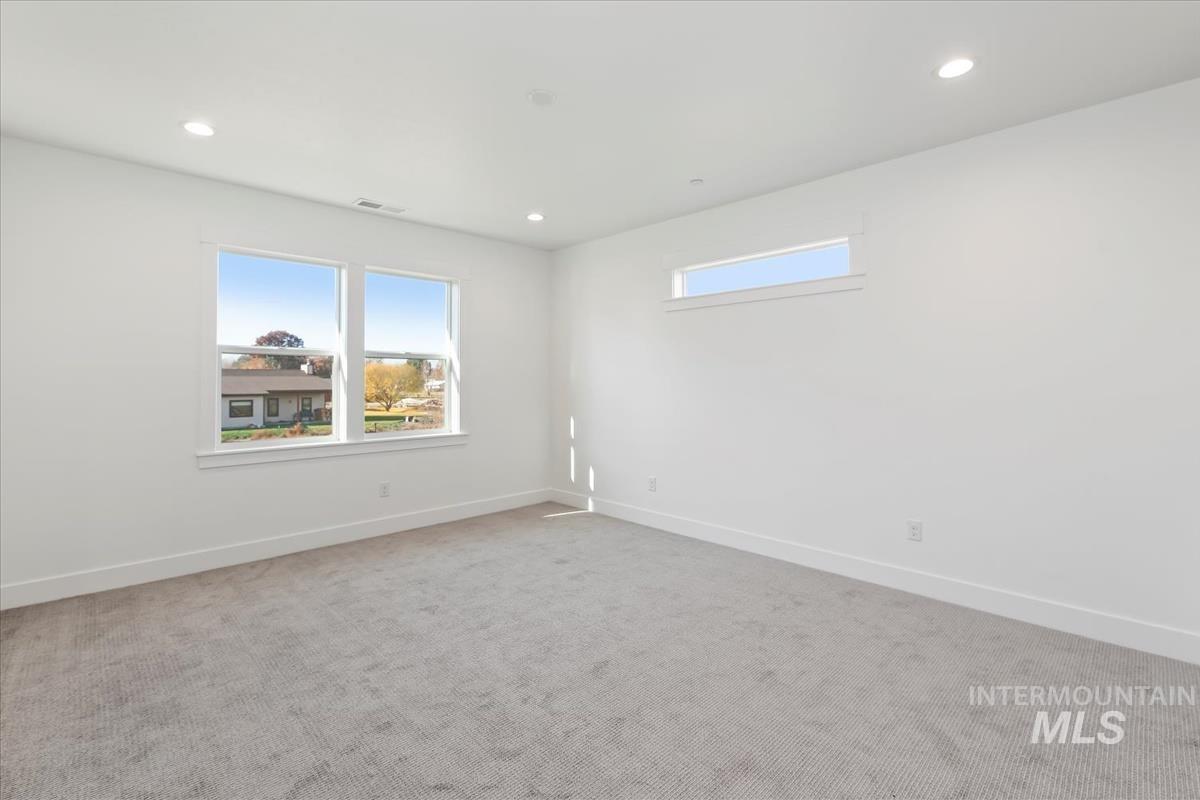 Empty room featuring light carpet and recessed lighting