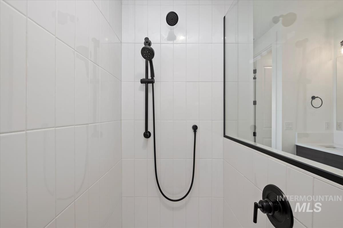 Bathroom view of tiled shower and vanity