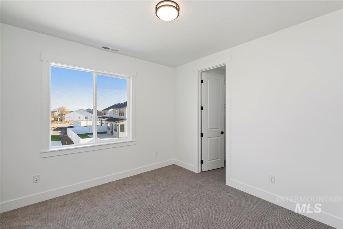 Spare room featuring carpet floors and baseboards
