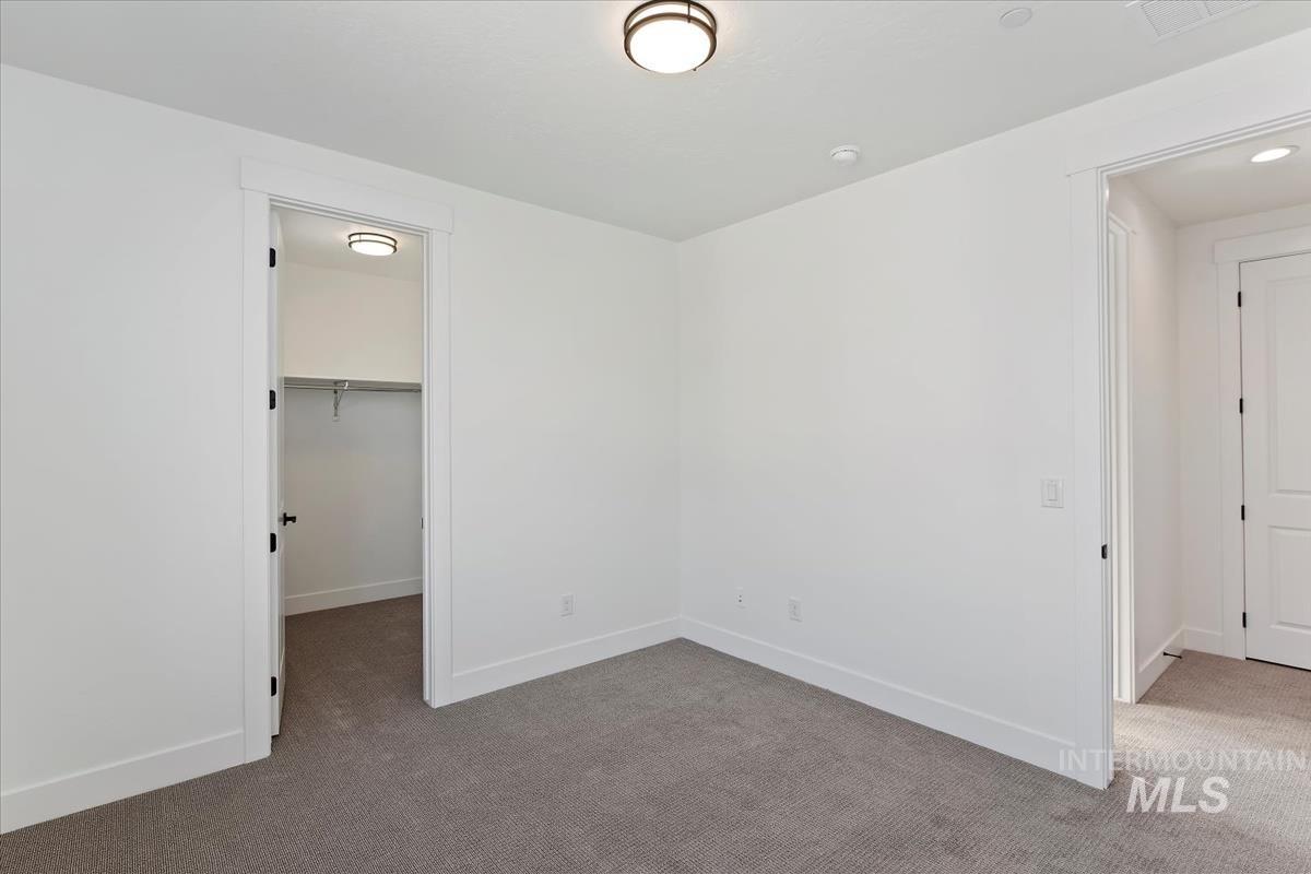 Unfurnished bedroom featuring carpet and a spacious closet