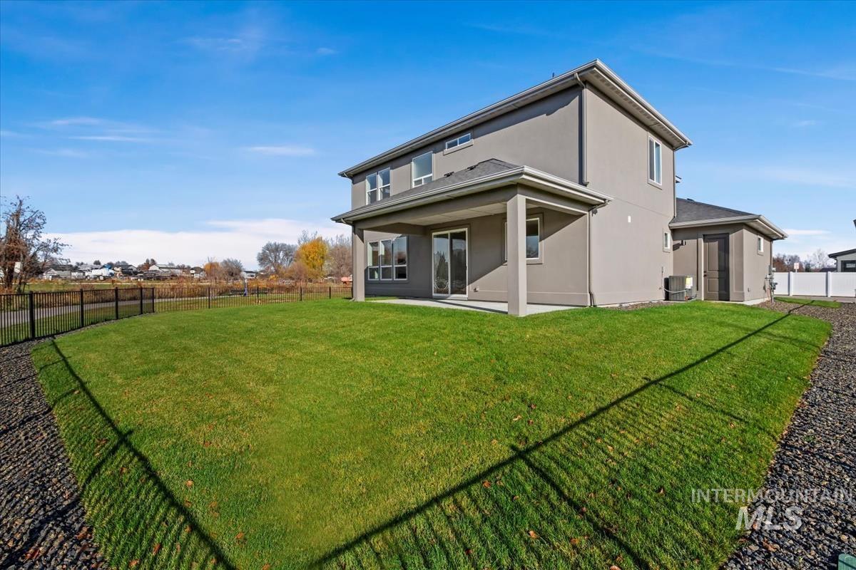 Rear view of property with a fenced backyard, a patio area, and stucco siding