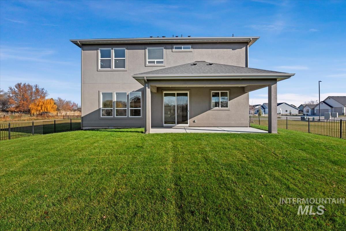 Back of house featuring a patio, stucco siding, and a fenced backyard