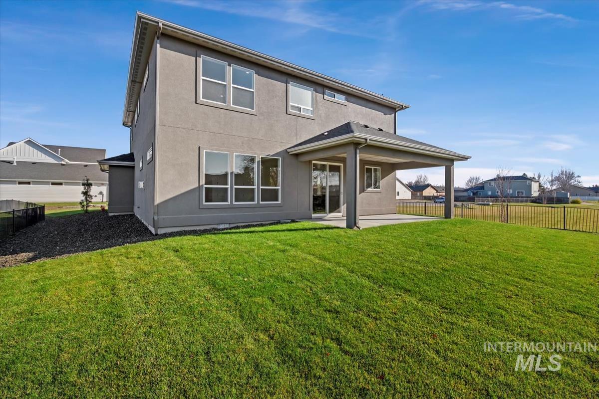 Rear view of property with a patio area, a fenced backyard, and stucco siding