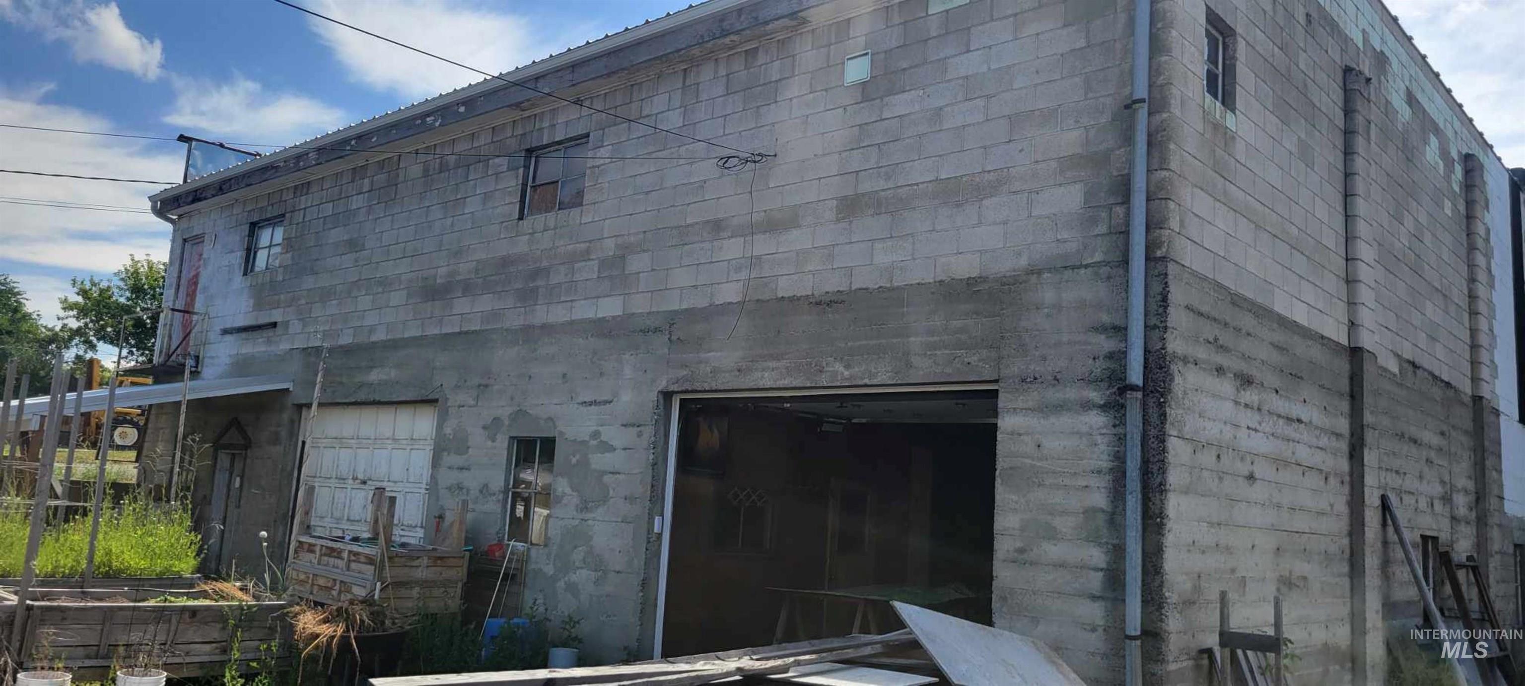 View of property exterior with concrete block siding and a garage