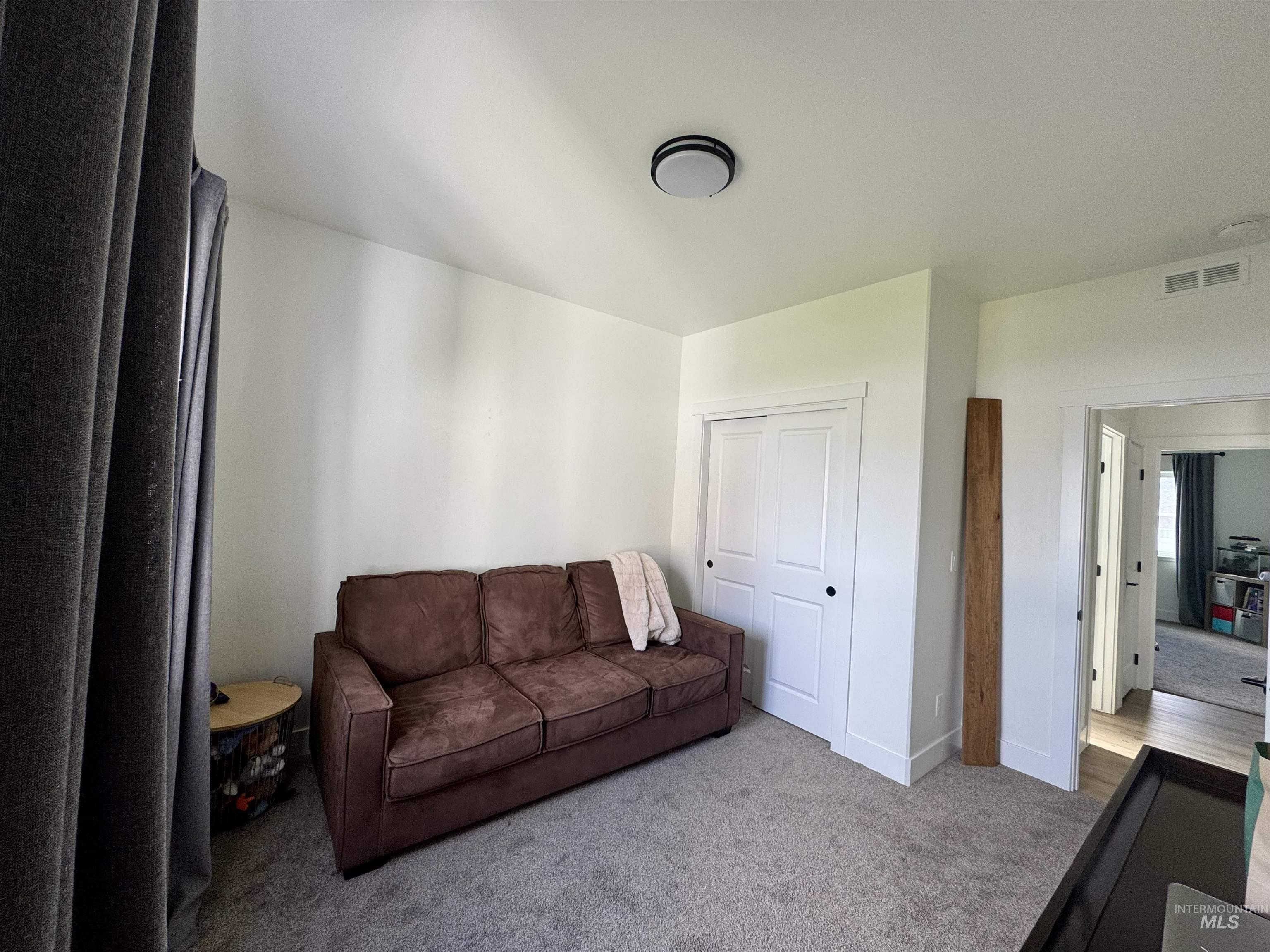 Living area featuring carpet and baseboards